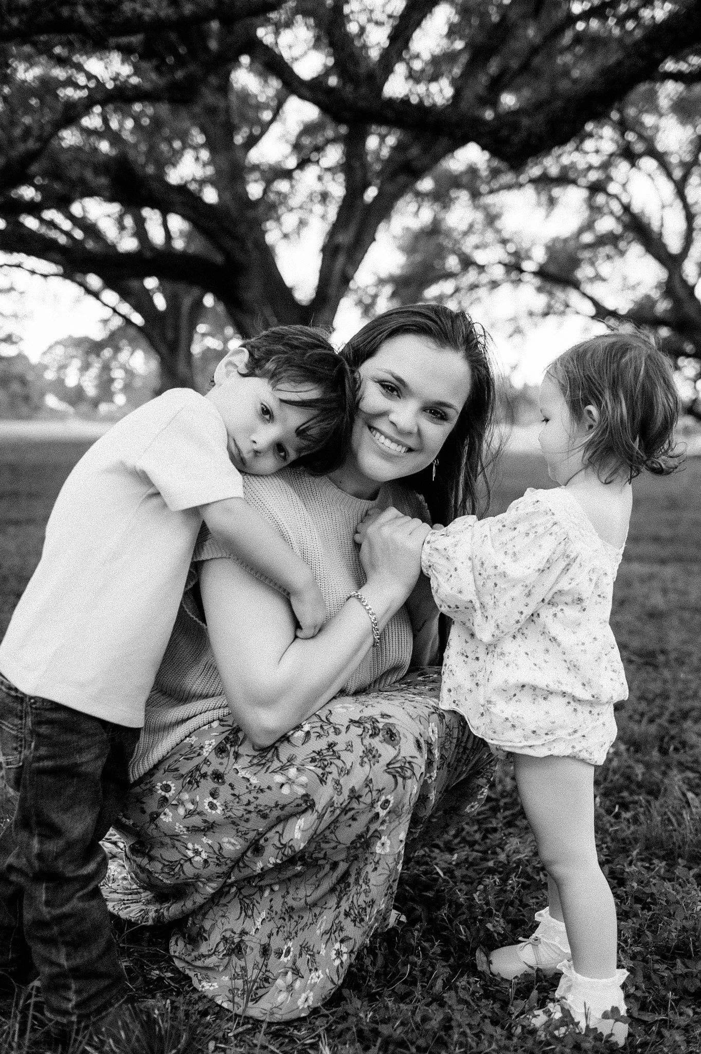 Black and white outdoor family photo of mom with two young children in The Woodlands Texas by Studio Brae
