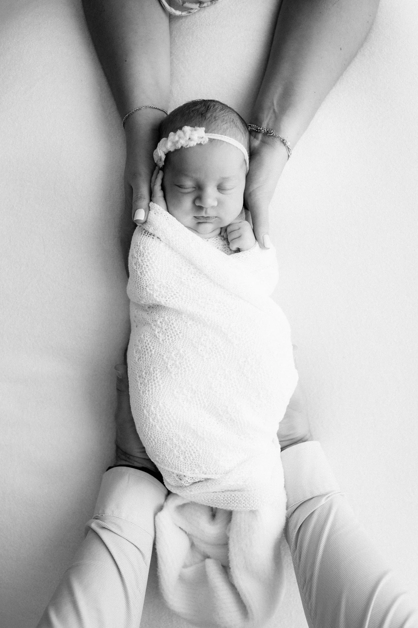 black and white photo of swaddled newborn baby during studio newborn session The Woodlands TX