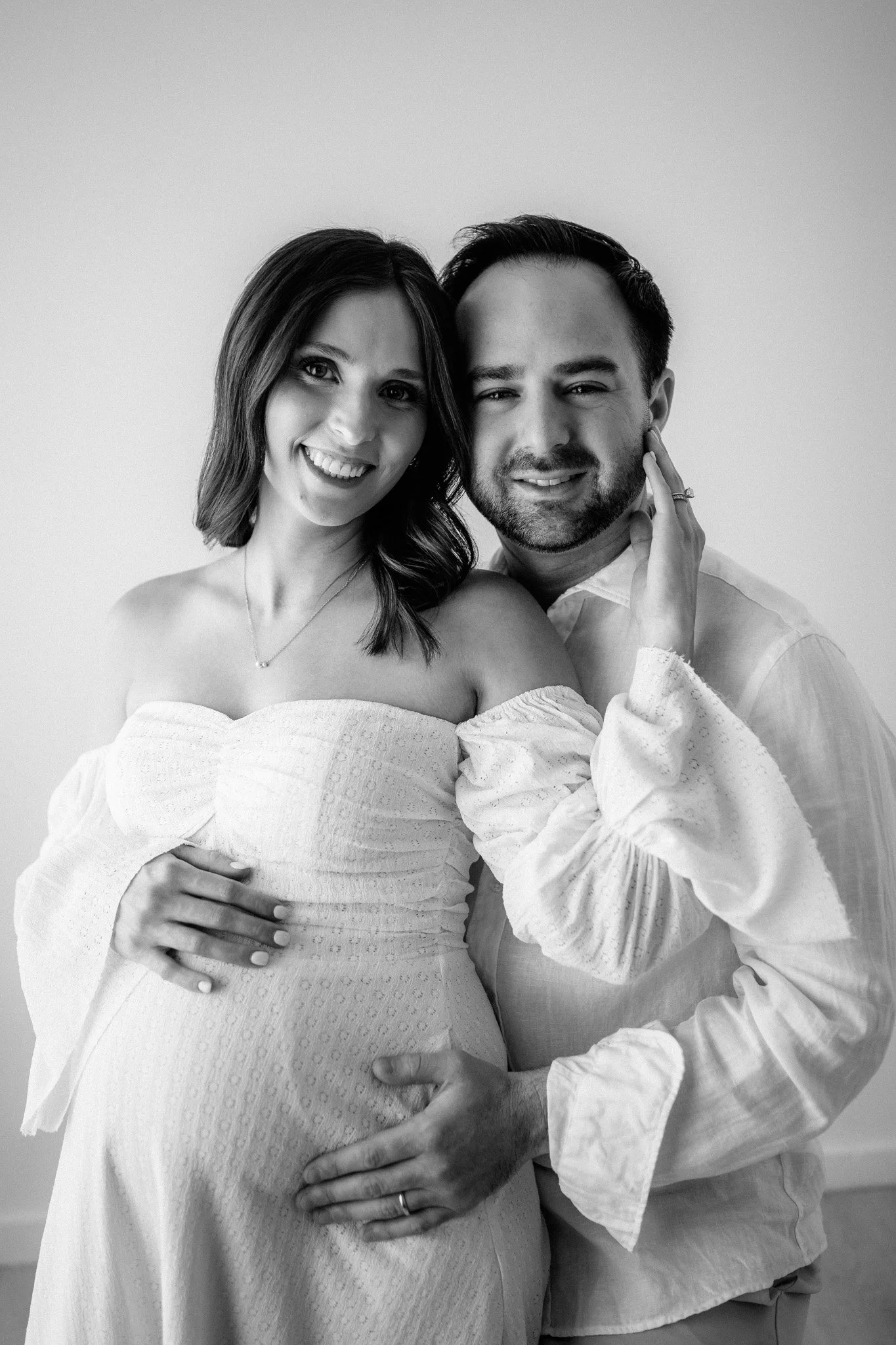 new mom and dad embracing for their maternity session in montgomery, texas photography studio