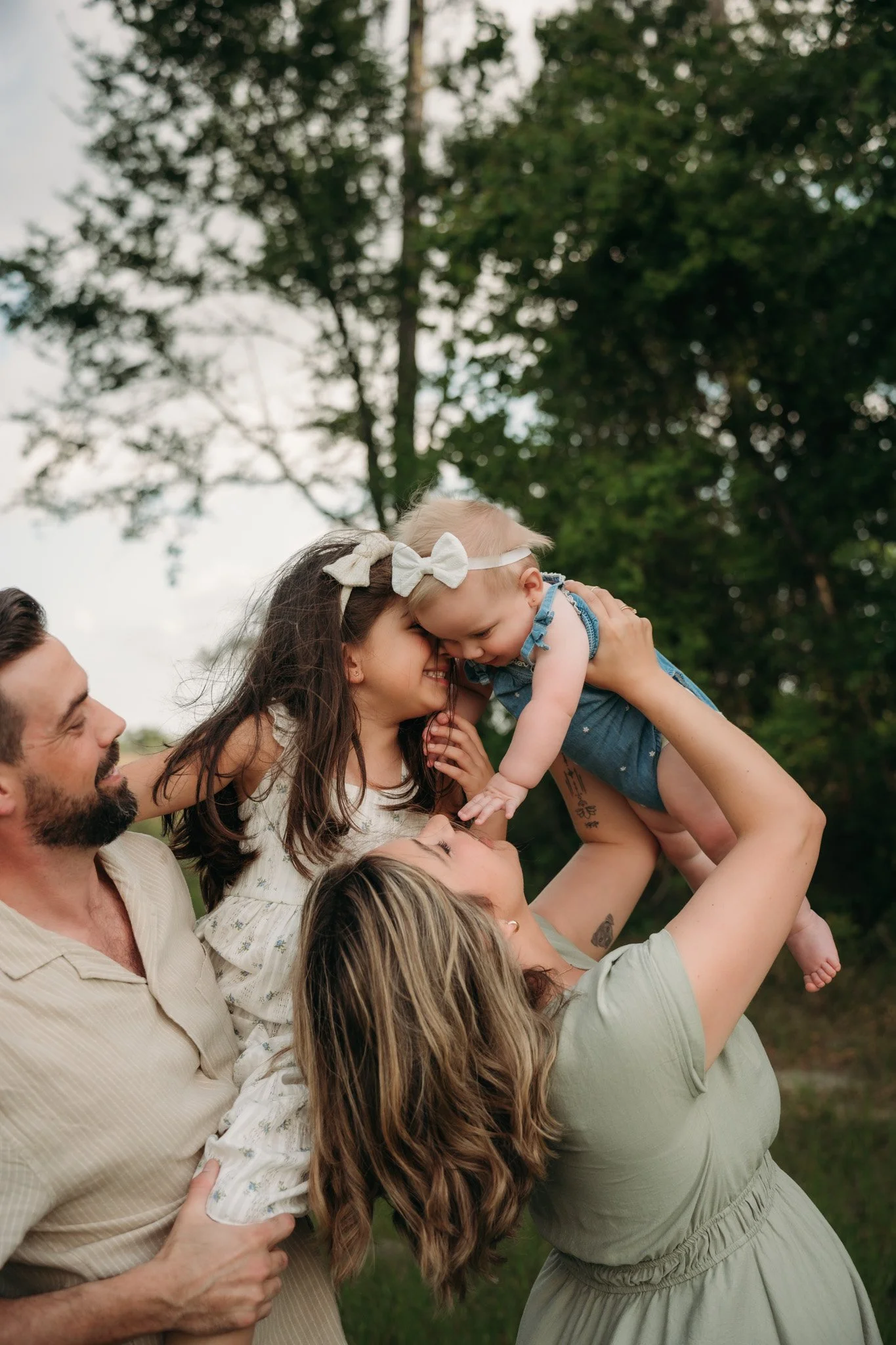 Family of four sharing playful moments outdoors during a Houston family photography session