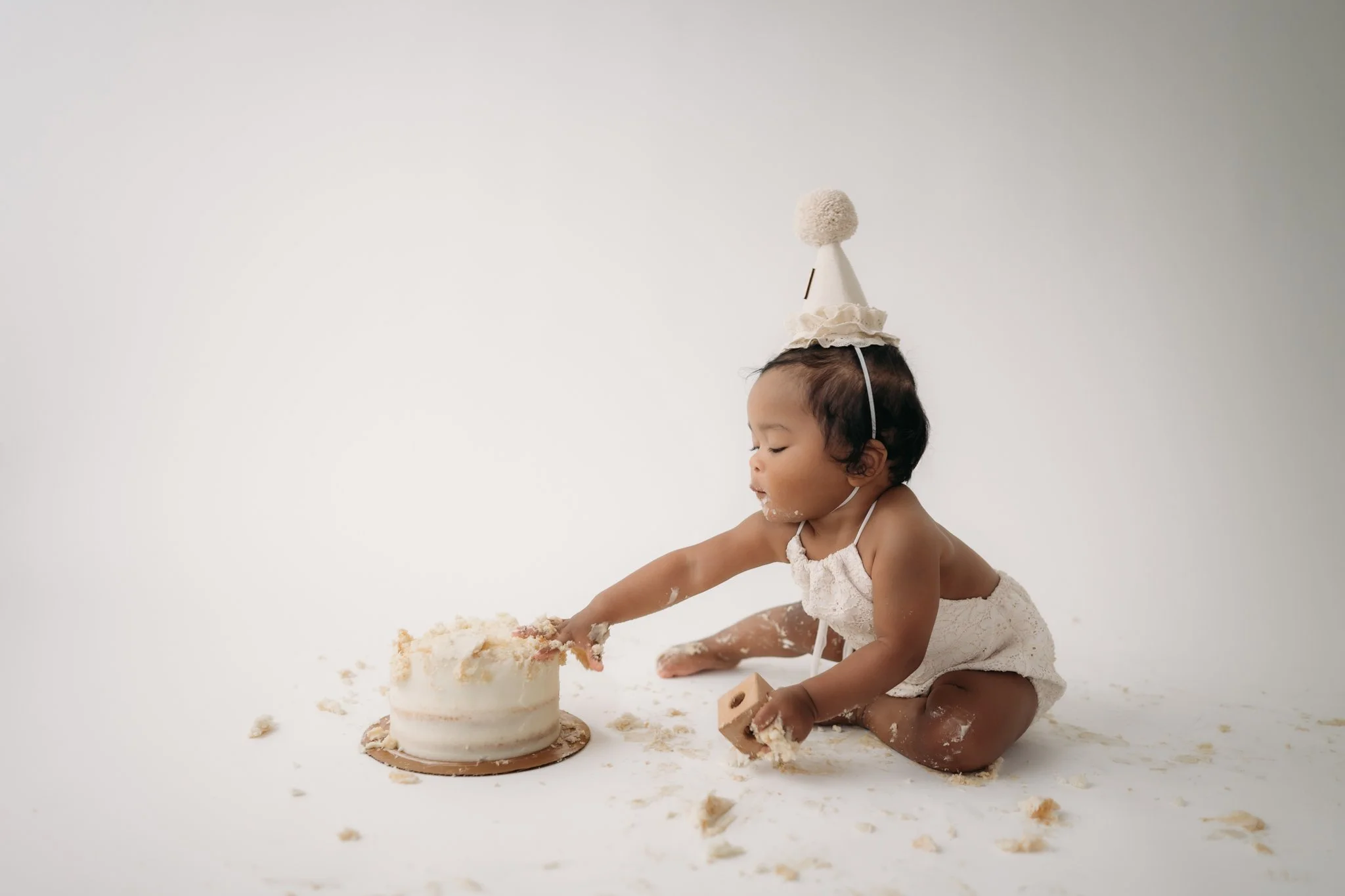 baby girl first birthday cake smash session with white cake Studio Brae The Woodlands TX
