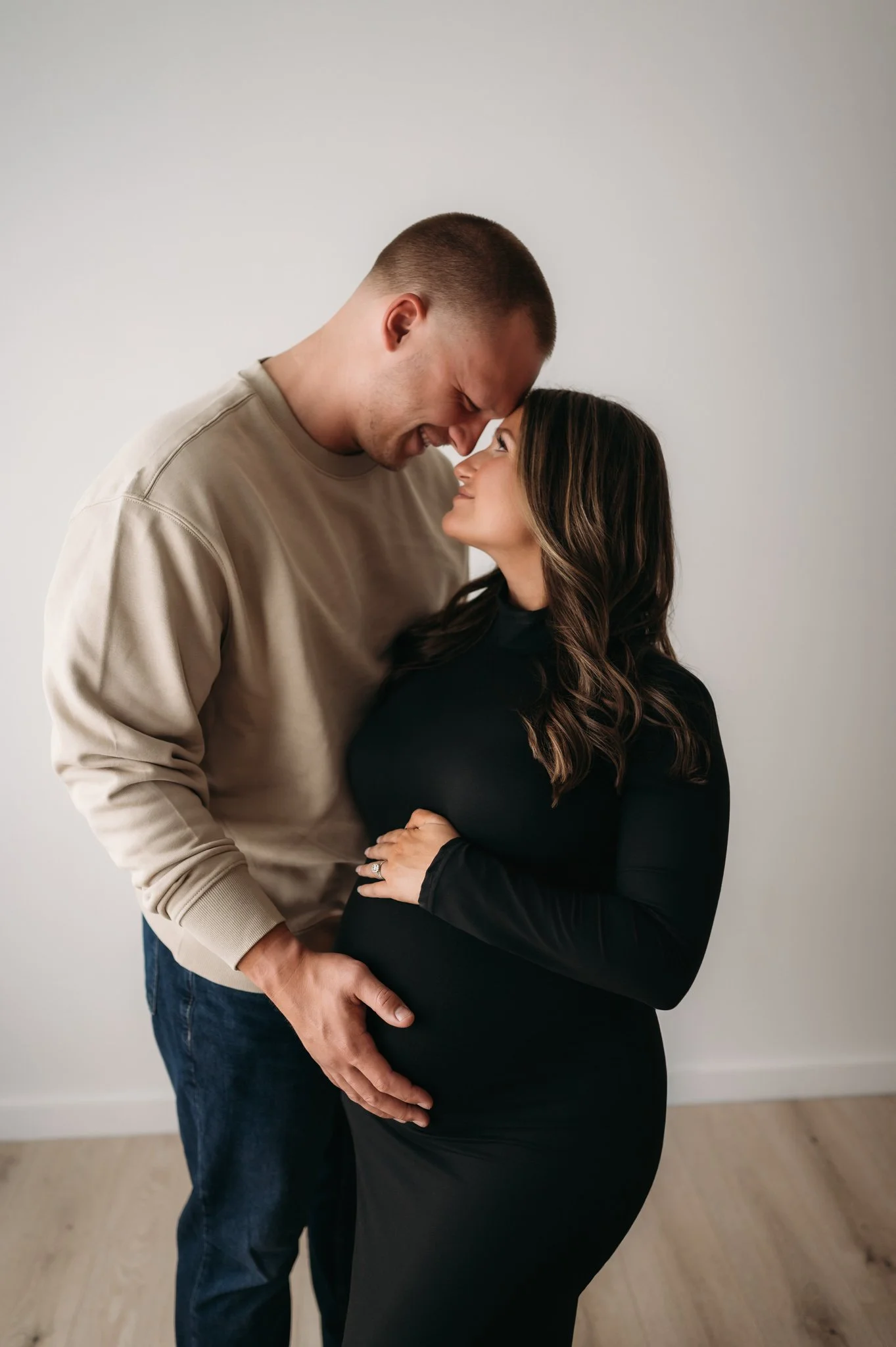 couple embracing and smiling at each other during maternity session in Houston TX
