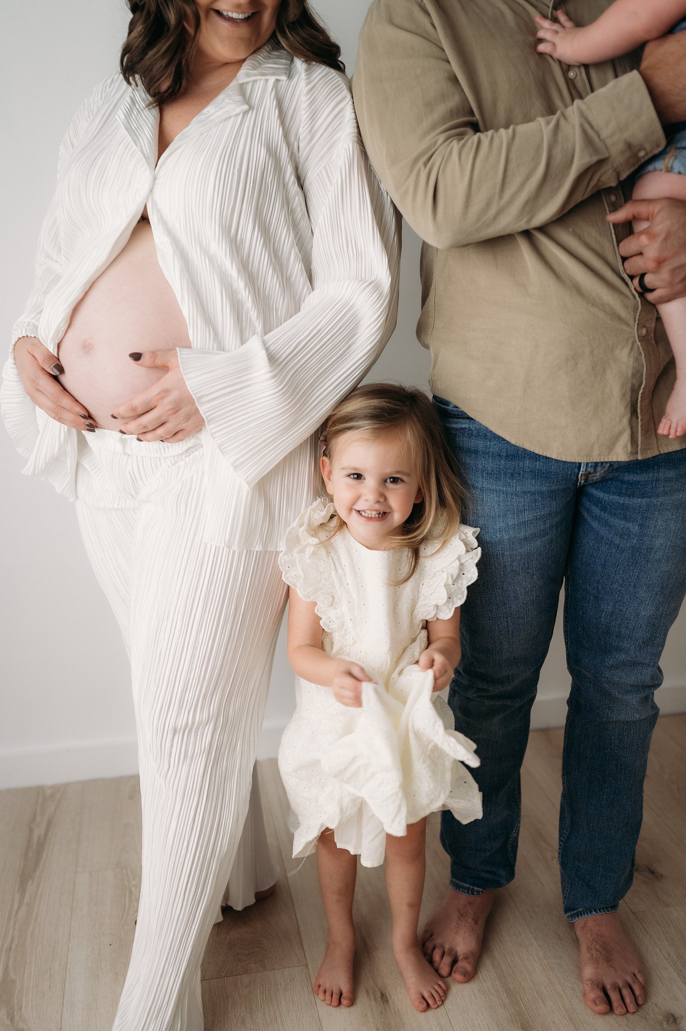 pregnant mother with toddler daughter and partner during studio maternity session The Woodlands TX