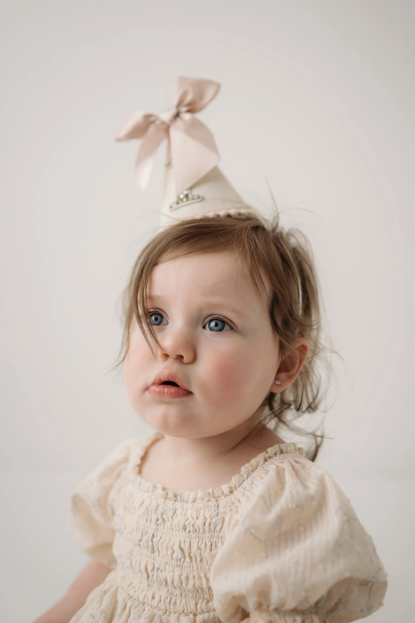 First birthday portrait of a baby girl during a milestone and cake smash photography session in Houston, Texas