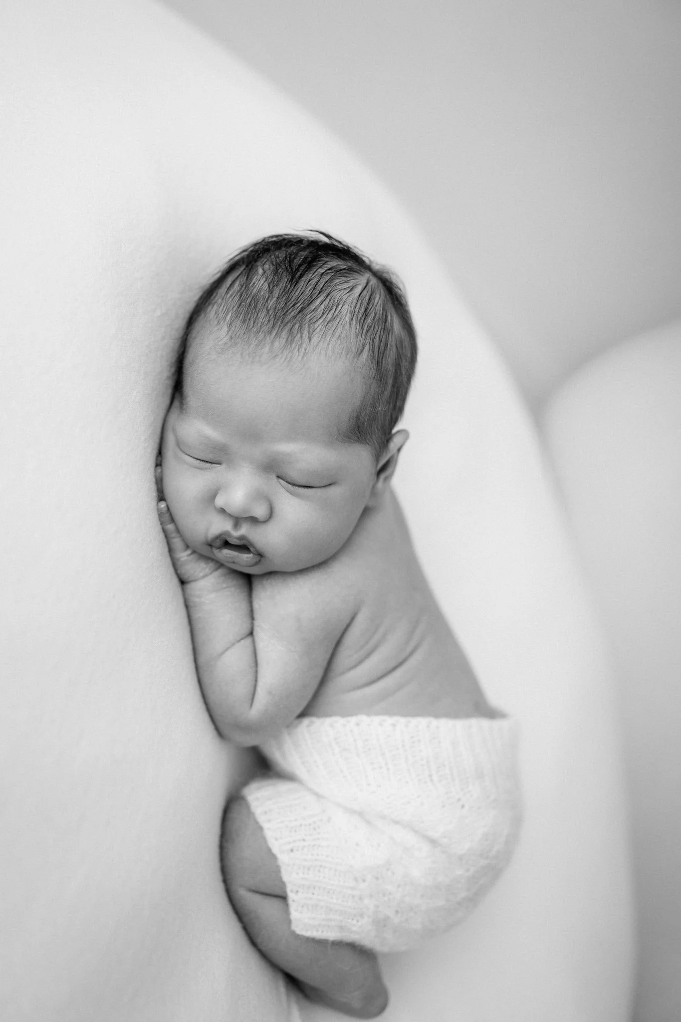 black and white photo of a baby in a neutral studio by studio brae in houston, texas