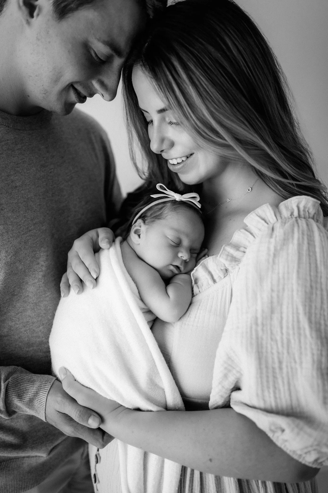 new mom and dad hold newborn baby in photography studio in the woodlands, texas