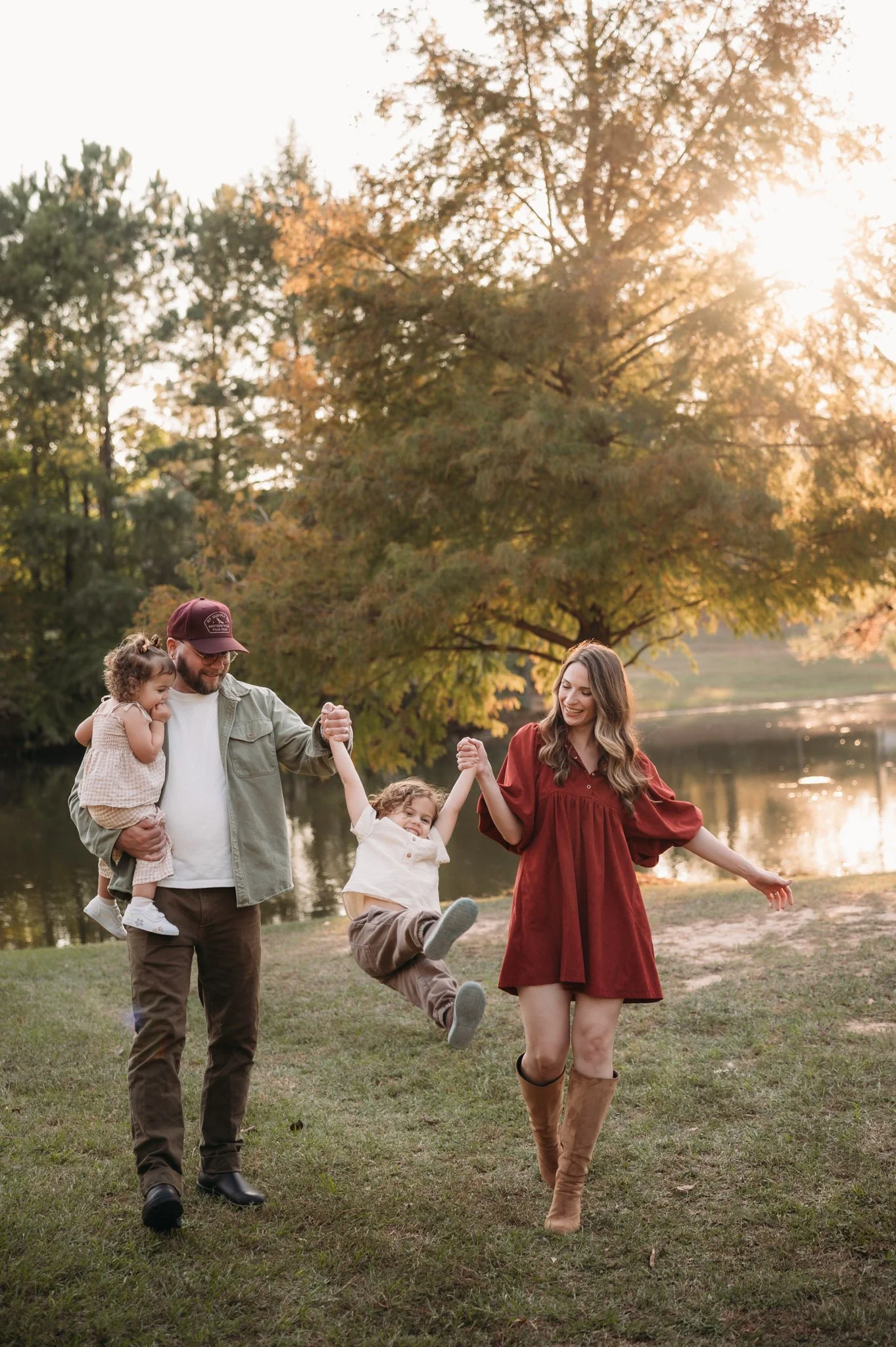 family of four playing and laughing together during golden hour outdoor session The Woodlands TX