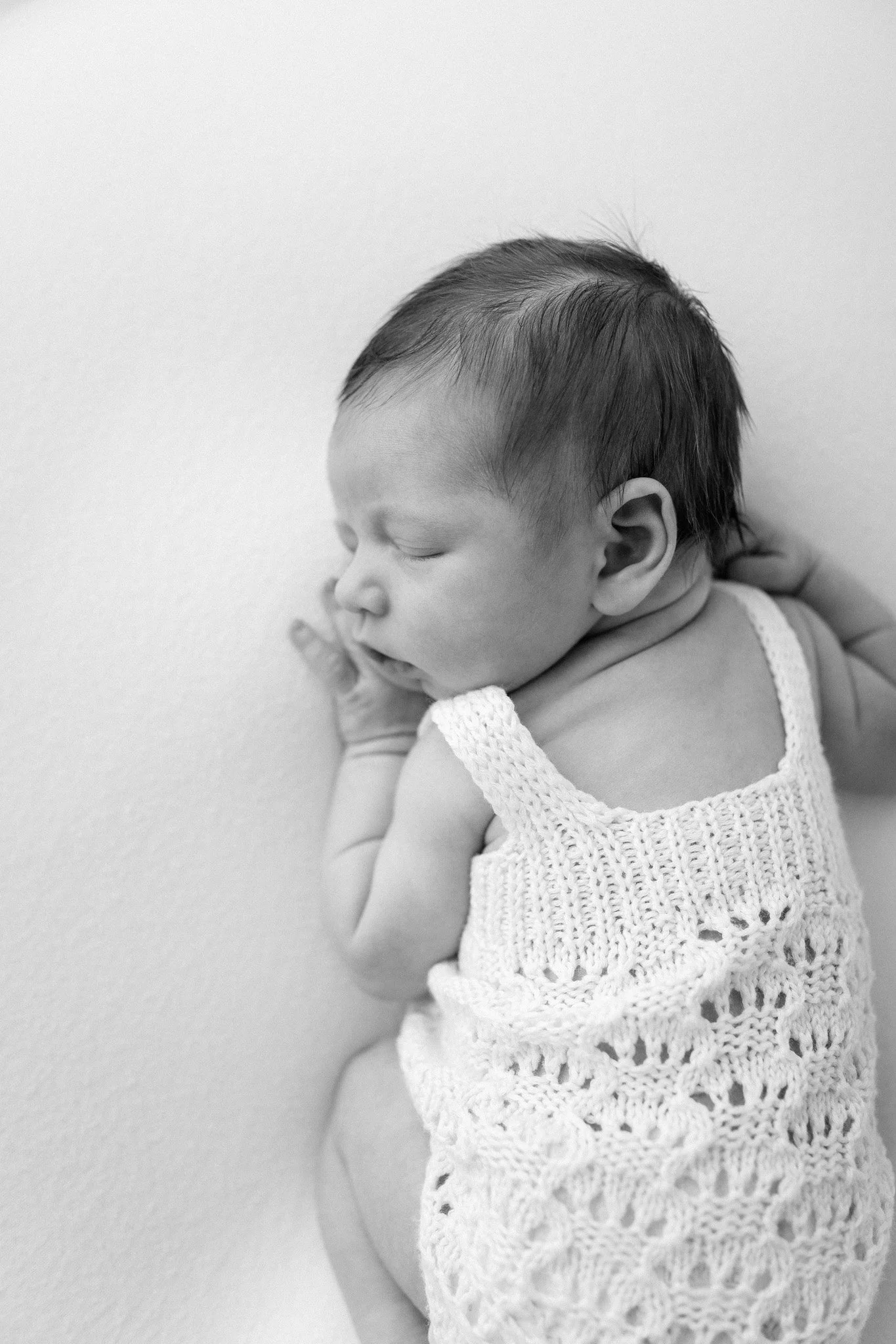 Sleeping newborn baby photographed in a bright, minimalist Houston newborn photography studio