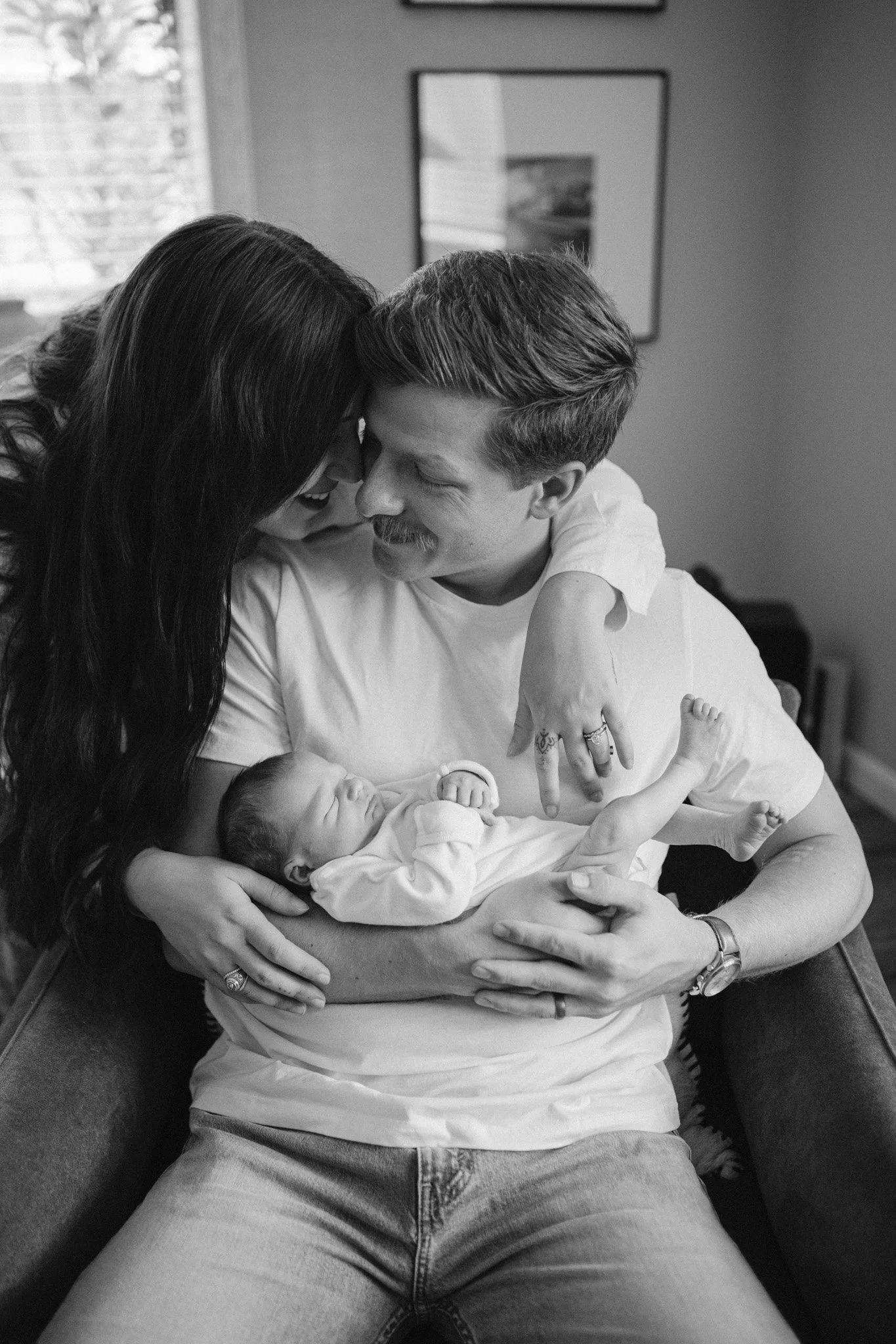 family pose with newborn baby for their in-home newborn session with the woodlands photographer, studio brae