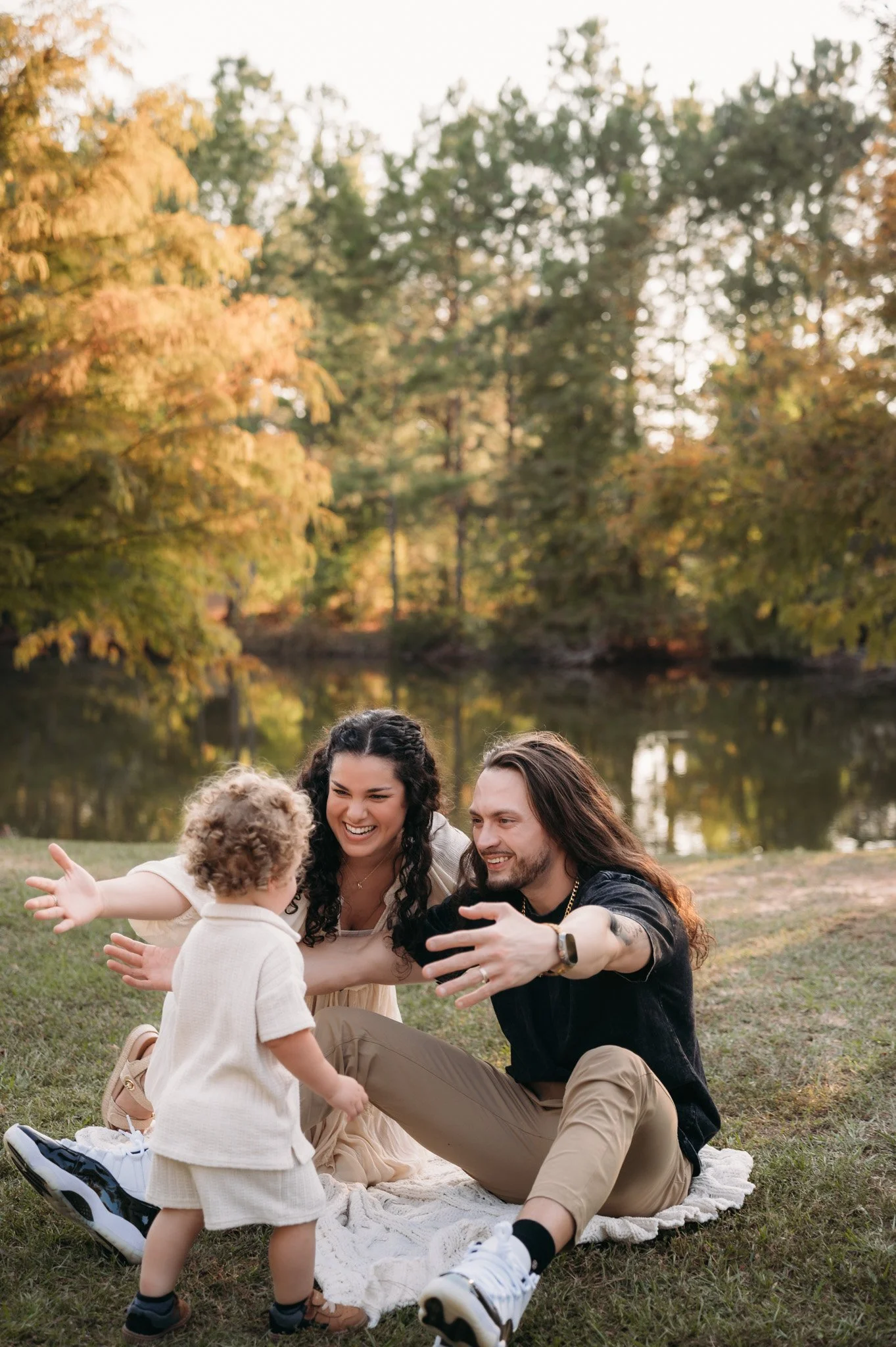 family playing together by pond during golden hour outdoor family session The Woodlands TX