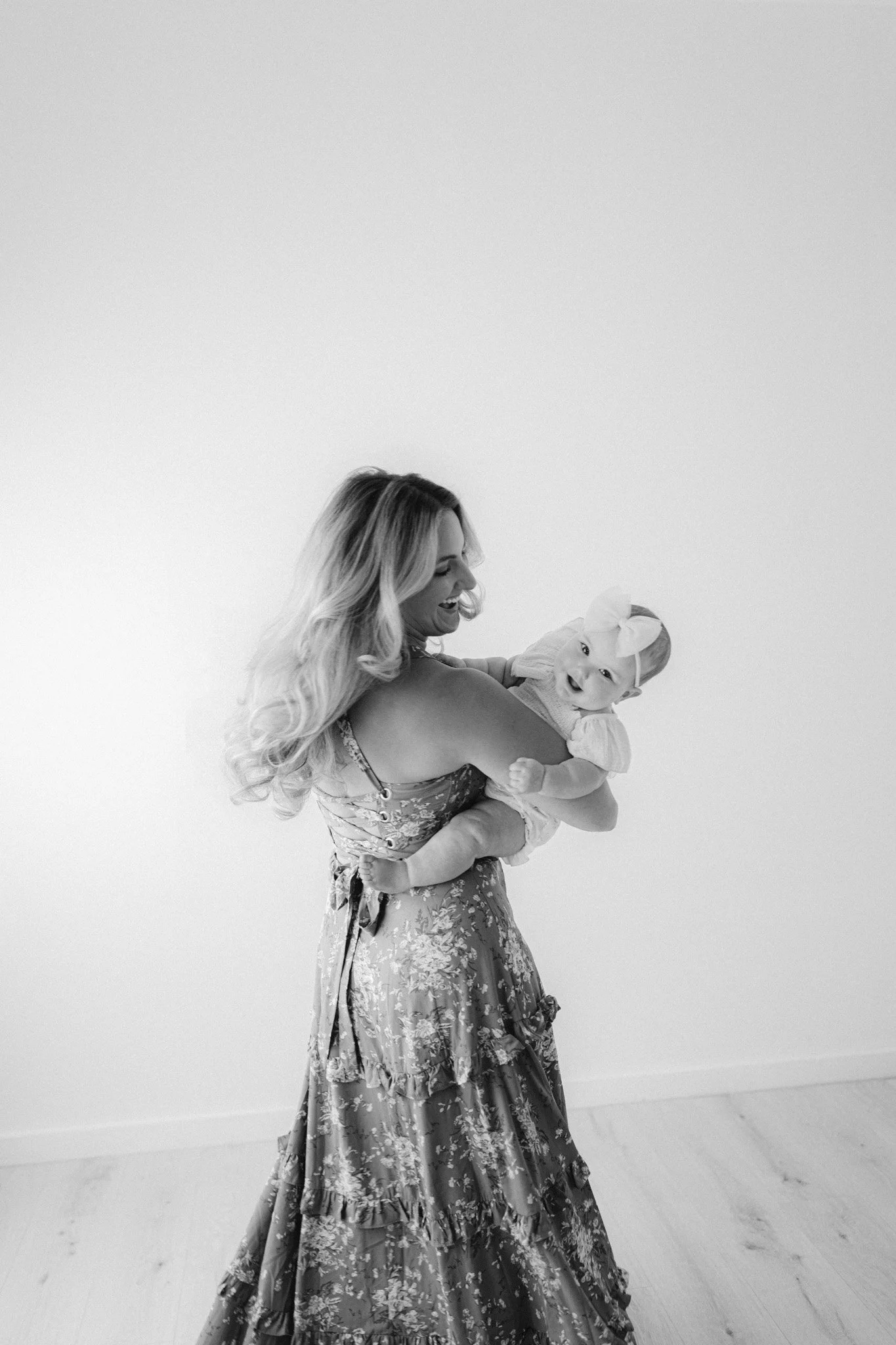 mom spins one year old baby around during their first birthday photoshoot in the woodlands, texas studio