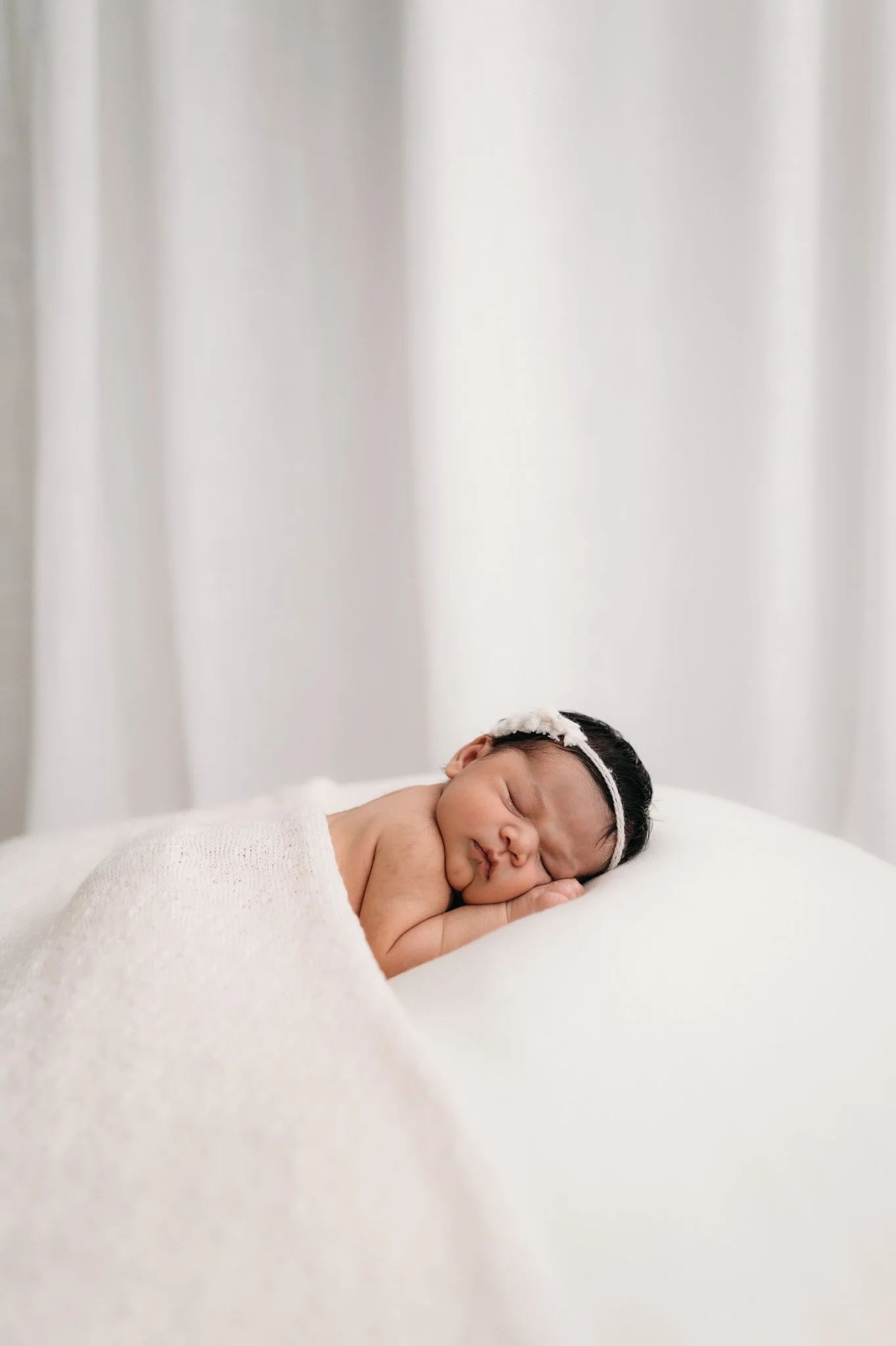 sleeping newborn baby on white blanket during studio newborn photography session The Woodlands TX