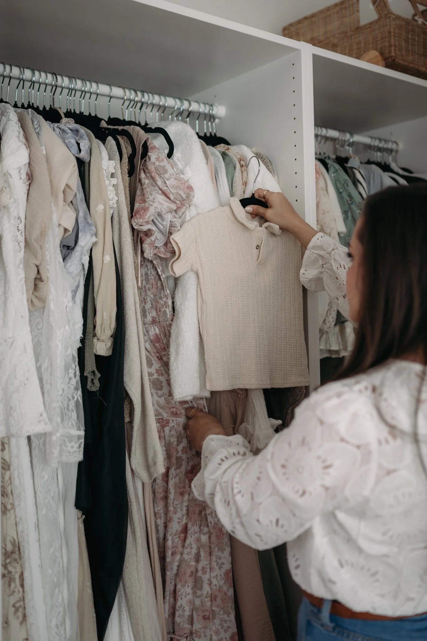 photographer selecting outfit from curated studio wardrobe for maternity and newborn sessions in The Woodlands TX