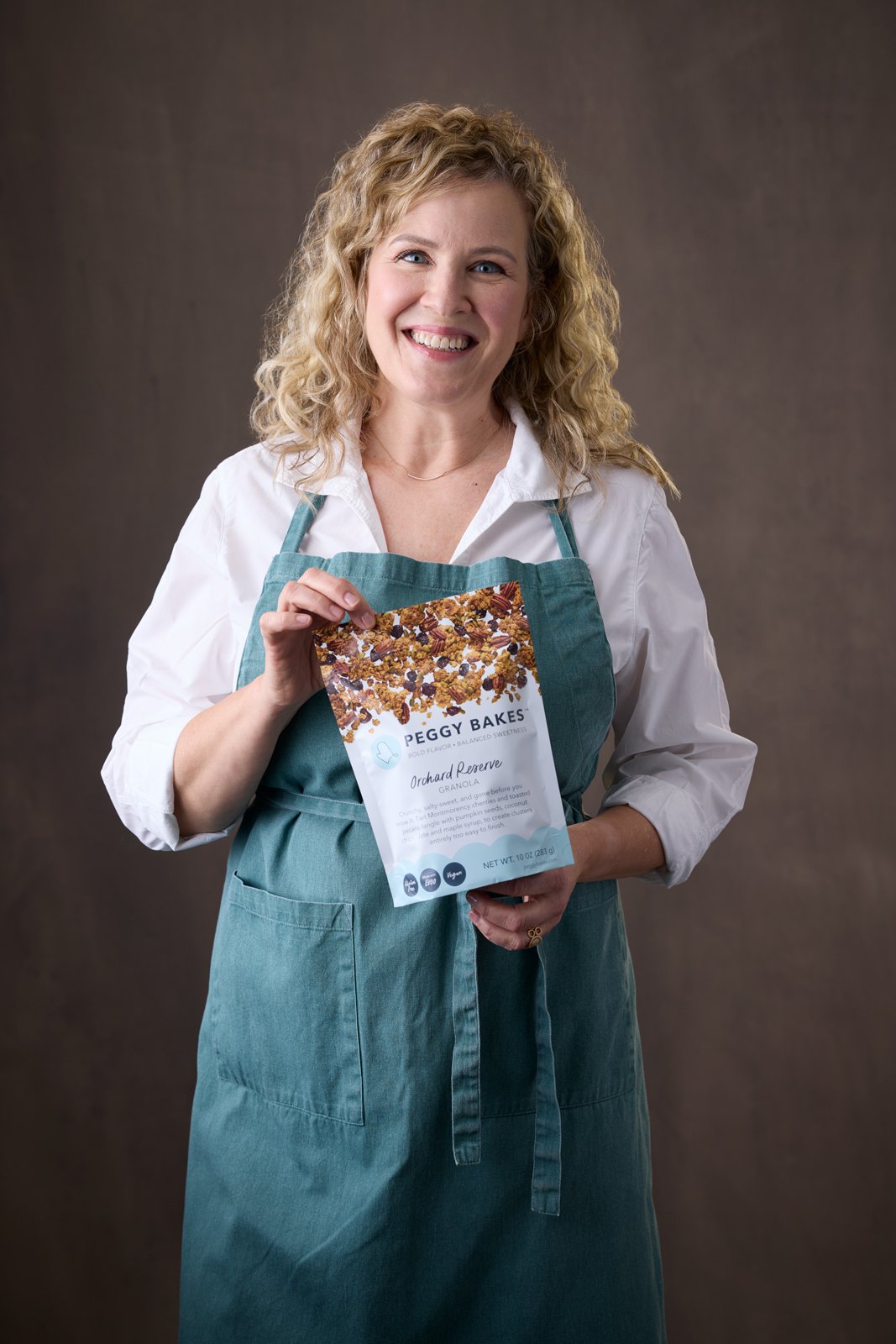 Peggy Bakes founder, Peggy Sonnenburg, holding a bag of her Orchard Reserve granola