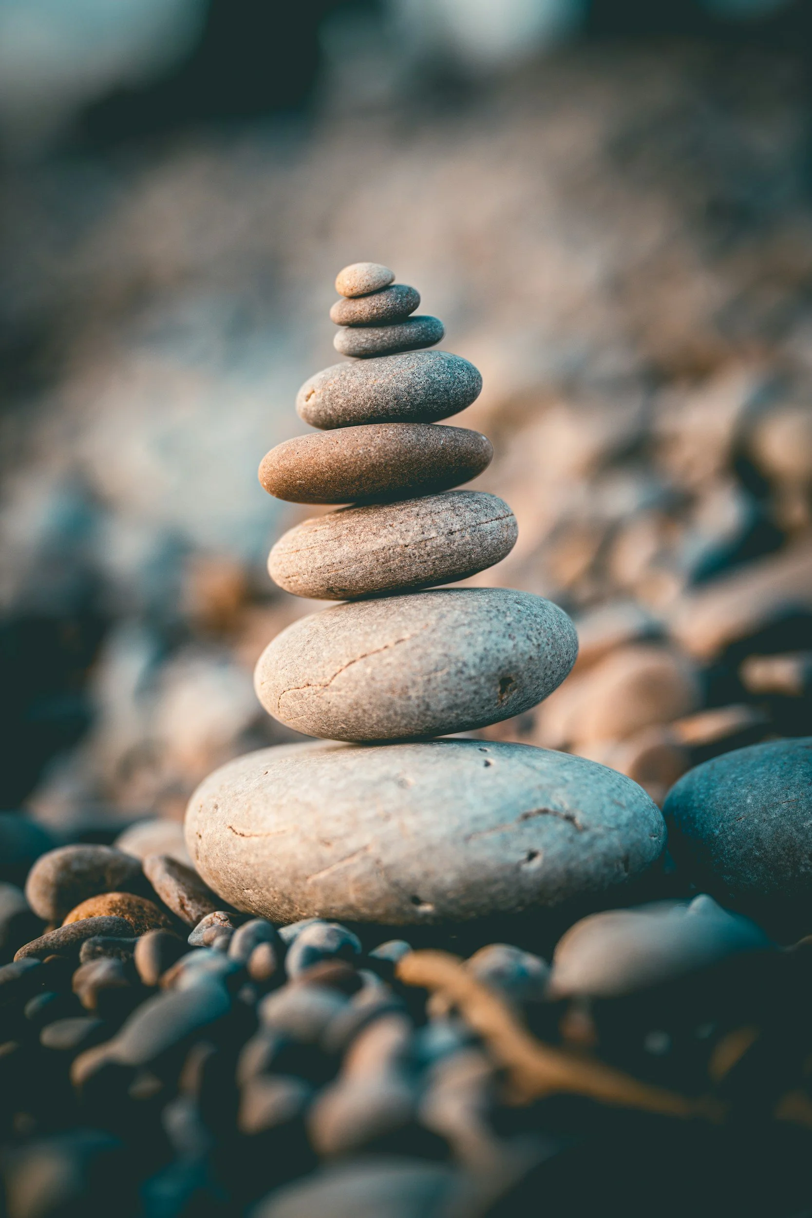 Stacked rocks on a beach with a blurred background.