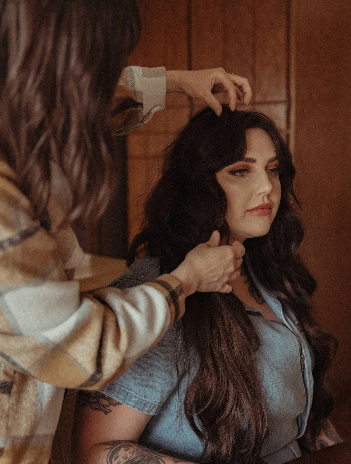 Stylist adjusts hair of a woman with a shag style haircut