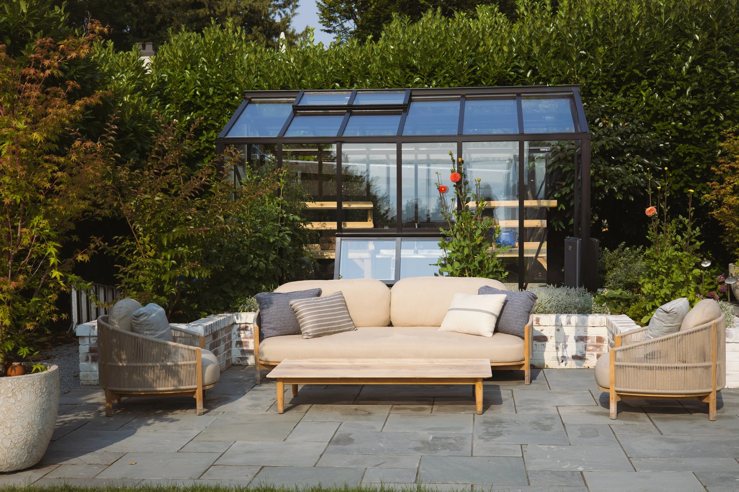 The new greenhouse creates a lovely back drop for this outdoor living room.