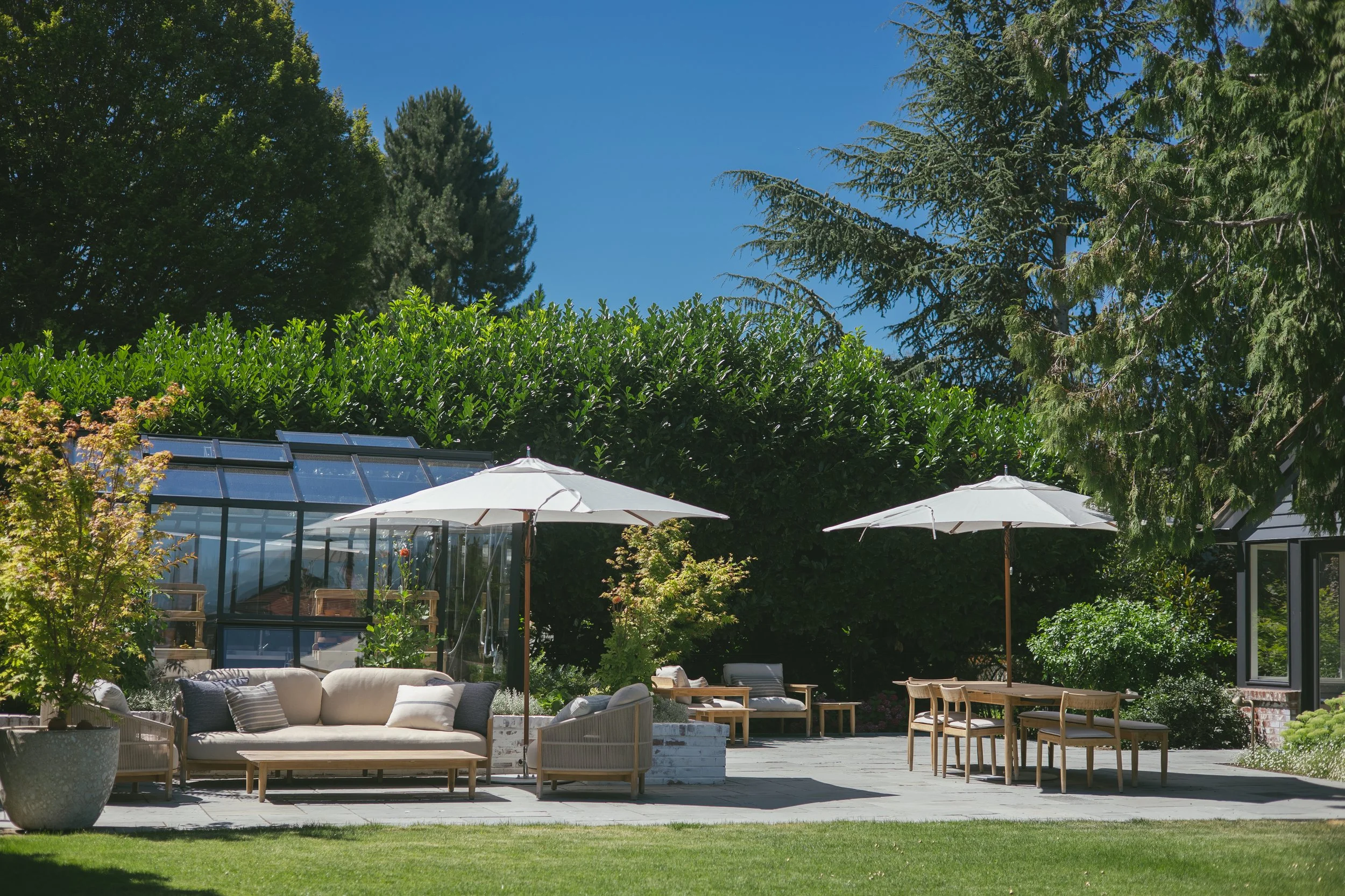 One large bluestone patio creates a much more functional space, divided into garden rooms with raised brick planters designed to look as though they had been there as long as the house.