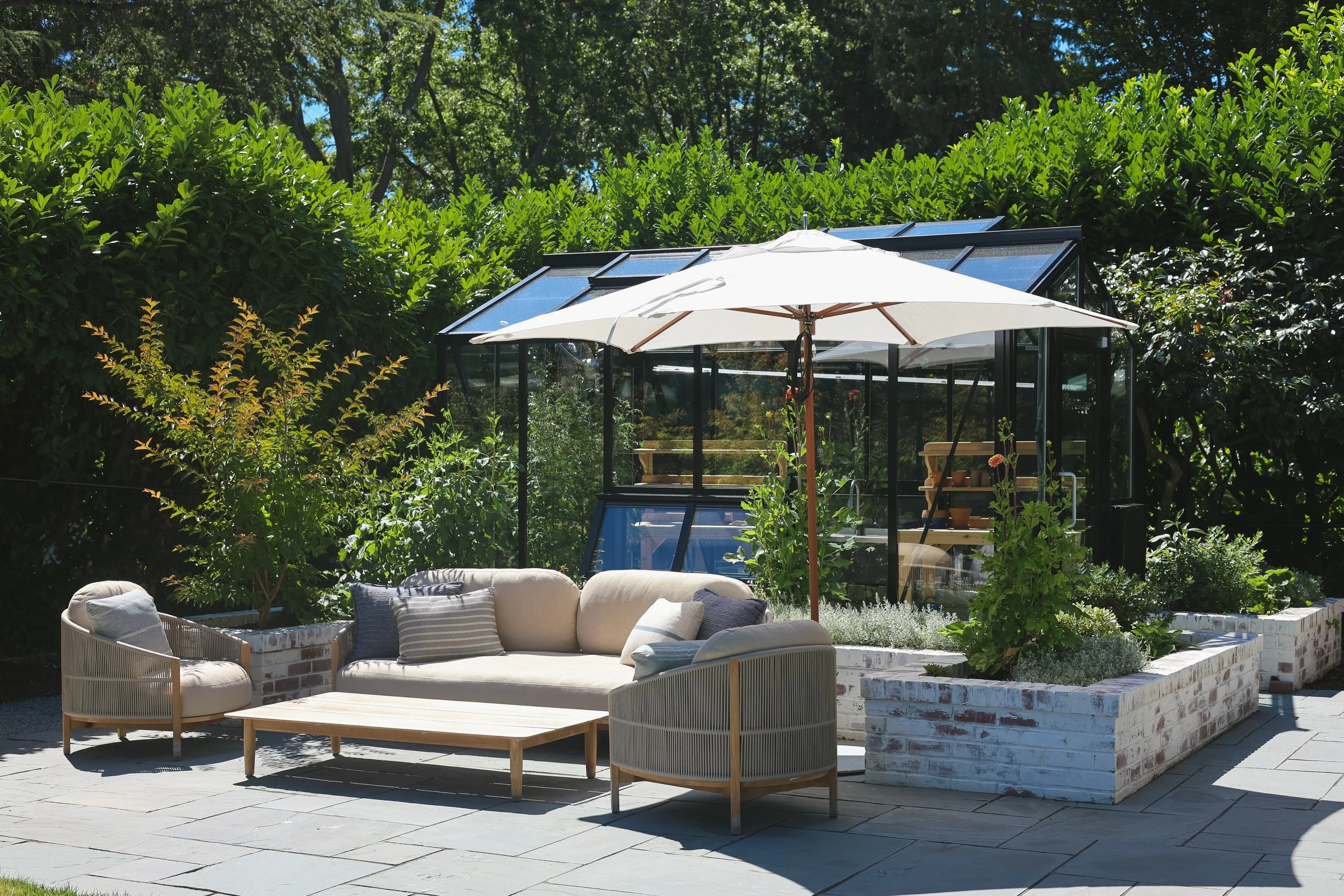 Custom brick raised planters add space for a mix of vegetables and ornamental plants, while doubling as walls to create structure and dimension throughout the patio. Whitewashed to match the home, they feel as though they have always been part of the