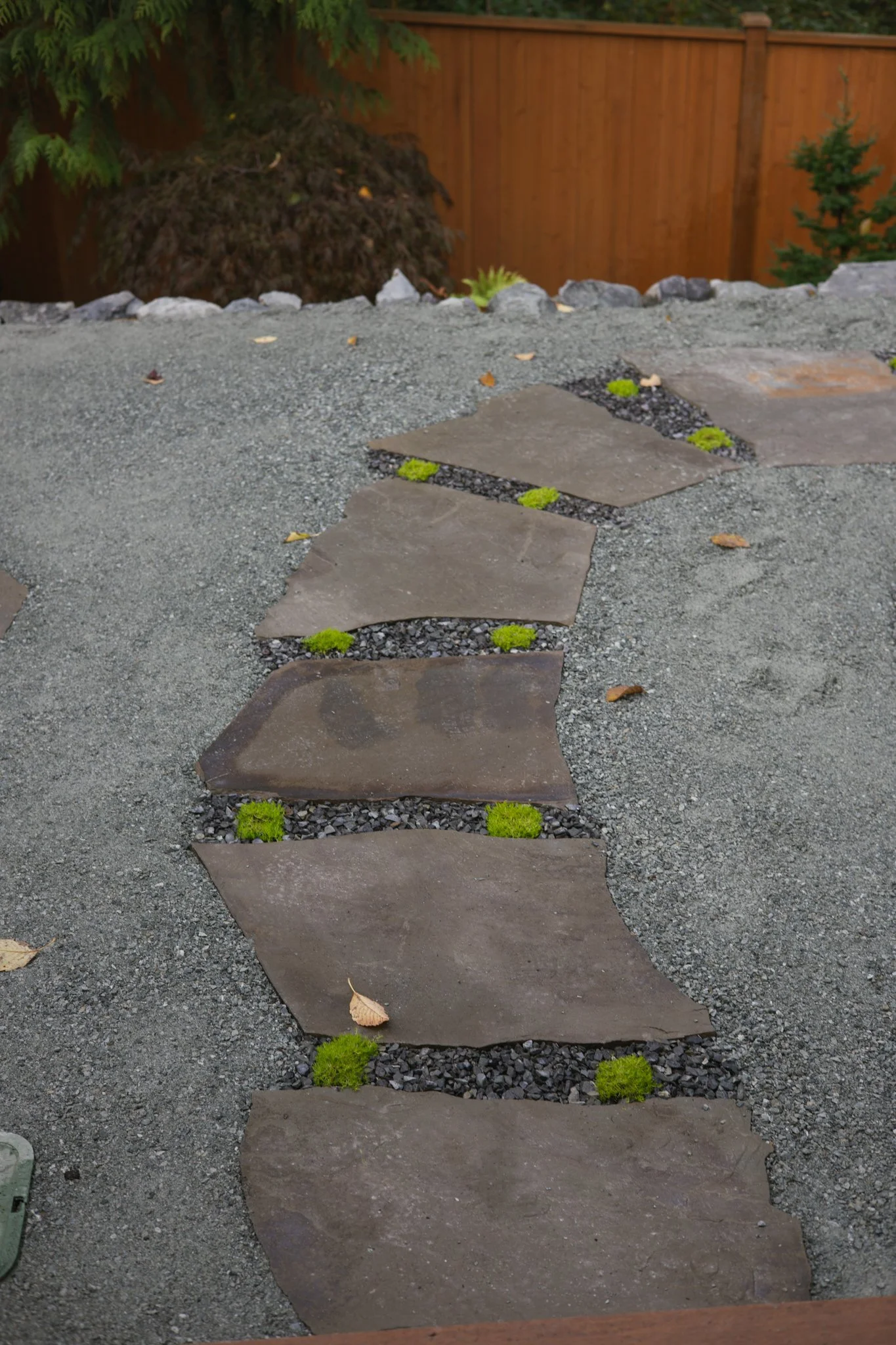 Contrasting gravel and stone surfaces introduce subtle shifts in texture while maintaining a cohesive material palette.