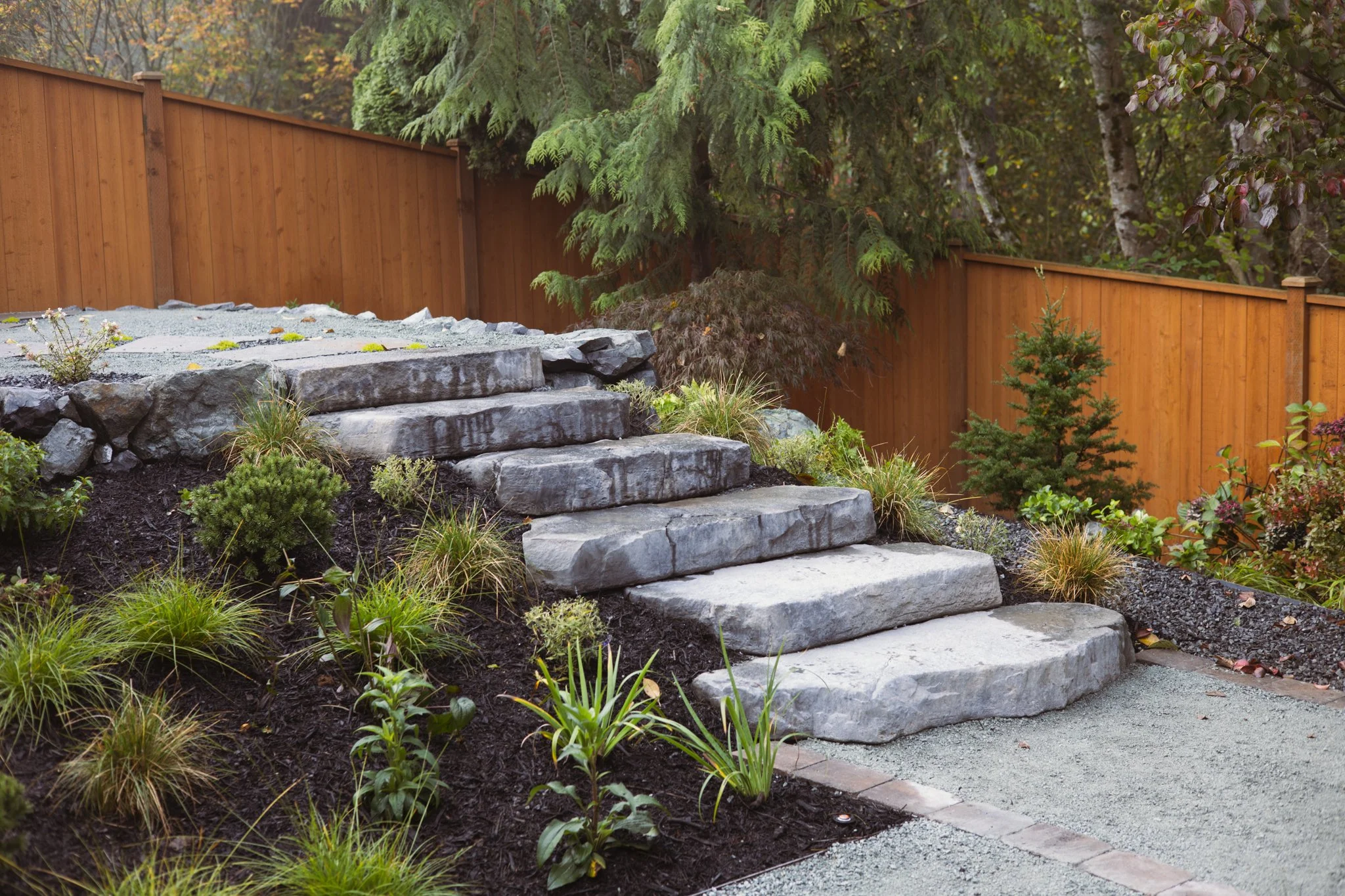 Substantial stone steps connect the garden’s different levels while creating a strong architectural focal point.