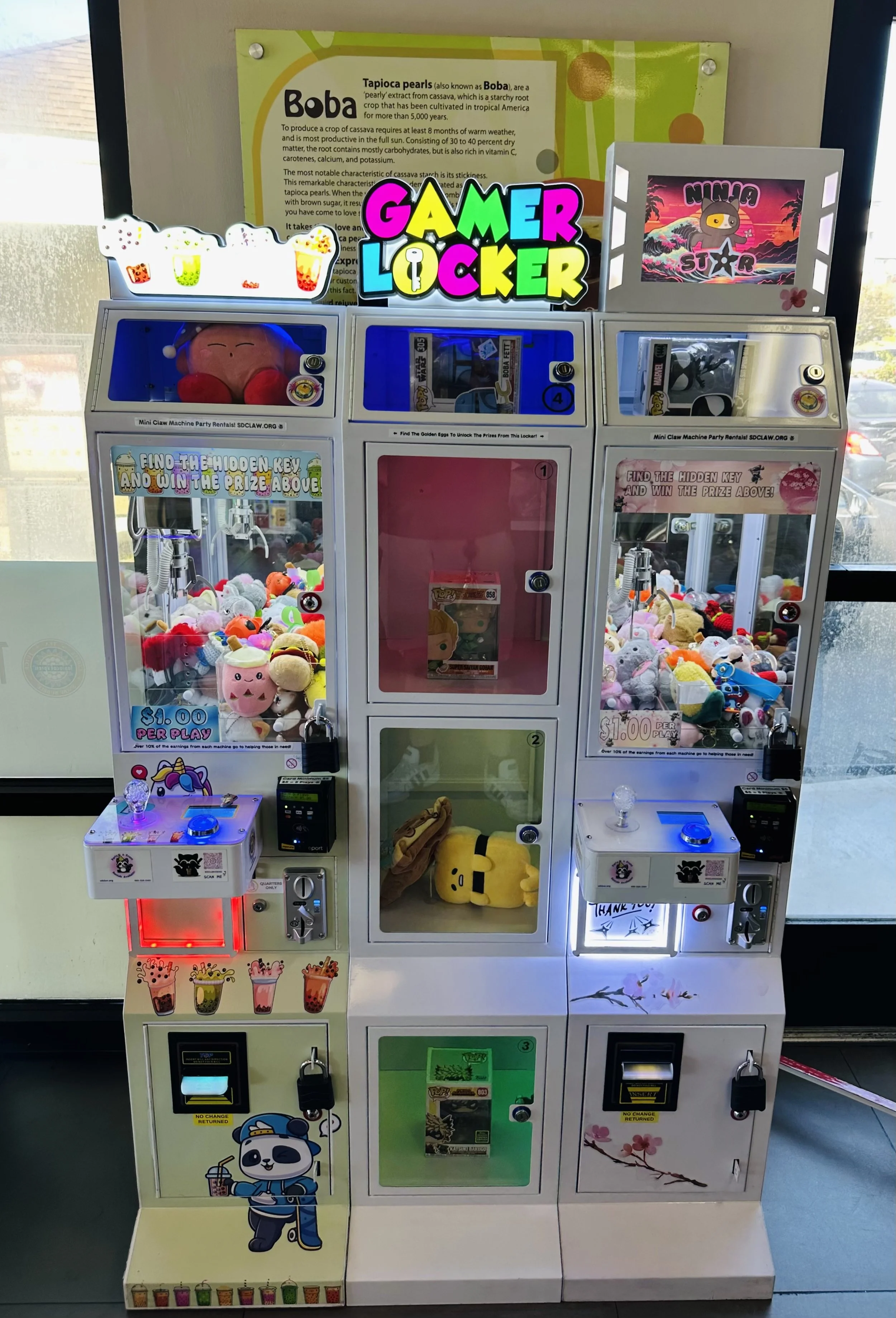 Colorful claw machines filled with plush toys and small prizes, decorated with various stickers and graphics, including a cartoon panda, a cartoon character holding bubble tea, and a ninja theme.