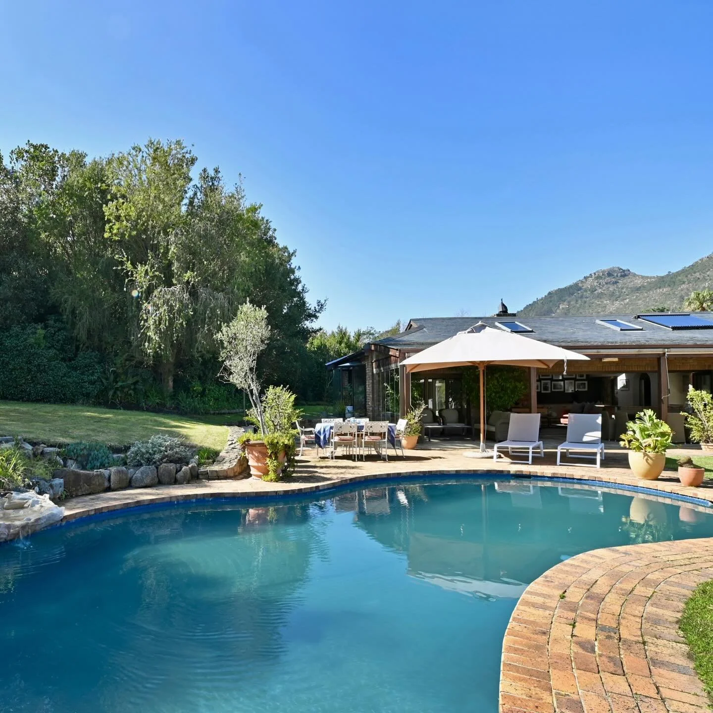Tucked away along Forest Hill Road in Hout Bay, this dreamy escape feels like stepping into your own private sanctuary. Lush gardens unfold around a shimmering pool, while every window frames a masterpiece of mountains and valley light. 

Between the