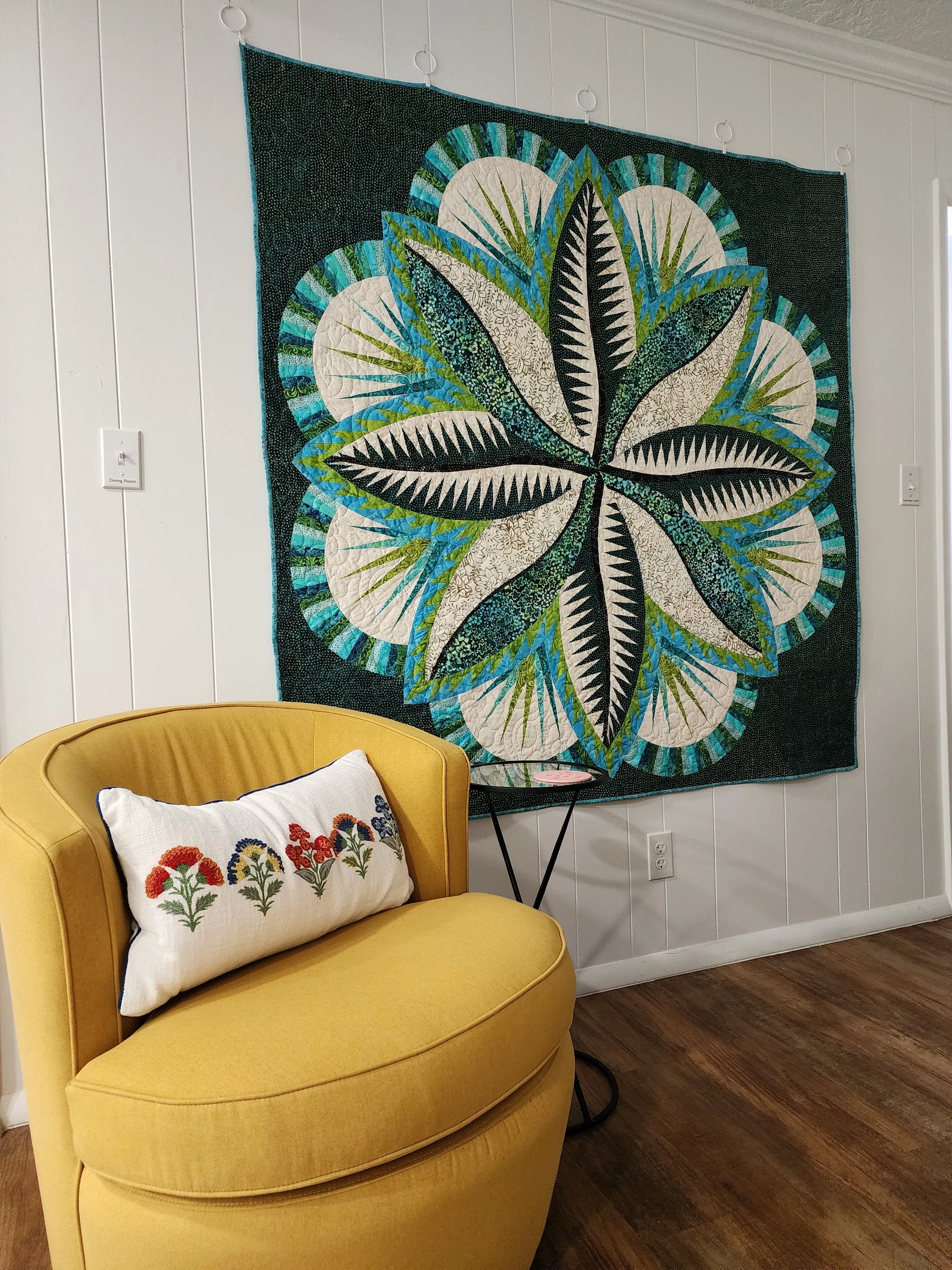 Cozy chair with quilt wall hanging in living room