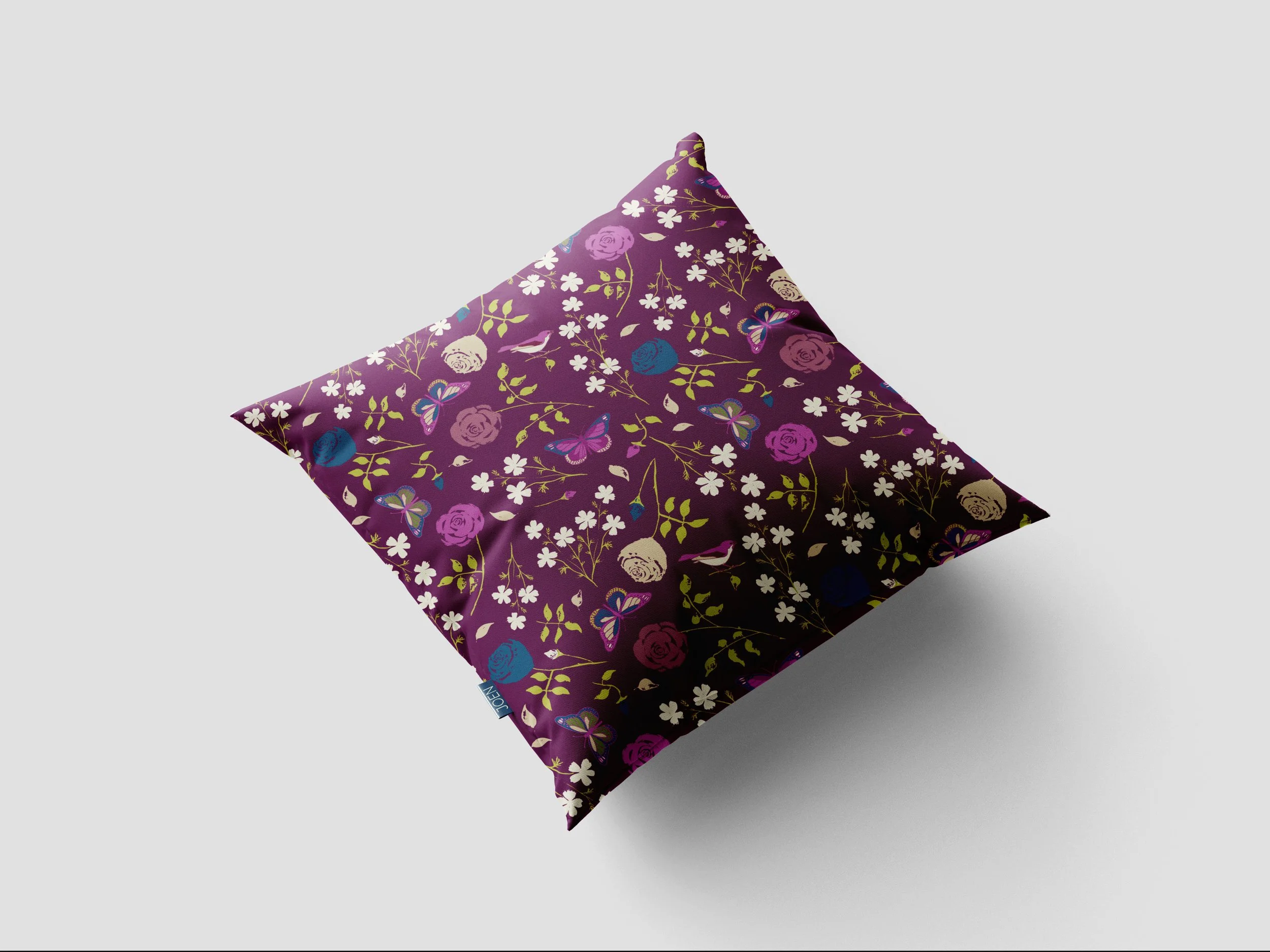 Purple fabric with floral and butterfly pattern, laid over a gray background.