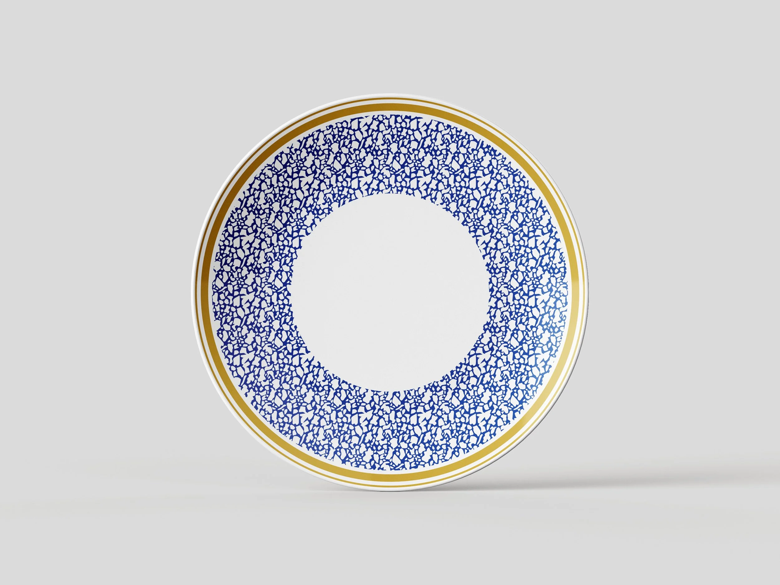 A decorative ceramic plate with a blue and white cracked pattern, bordered with gold.