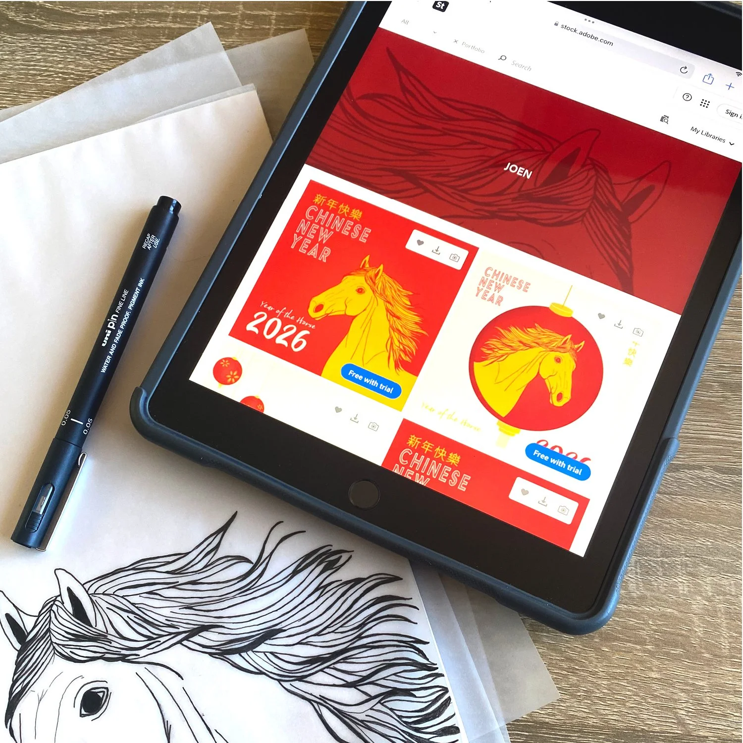 Desk with iPad showing assets, on the desk a line drawing of a horse