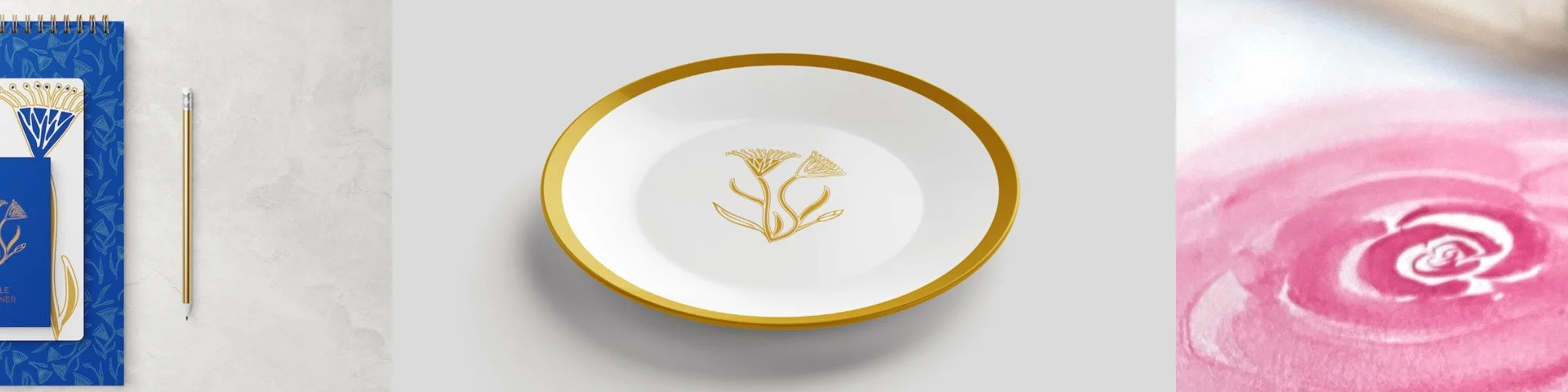 A white and gold decorative plate with a floral design, placed on a plain surface. To the left, blue patterned notebooks and a gold pen. To the right, a pink and white abstract floral pattern. Home decor.