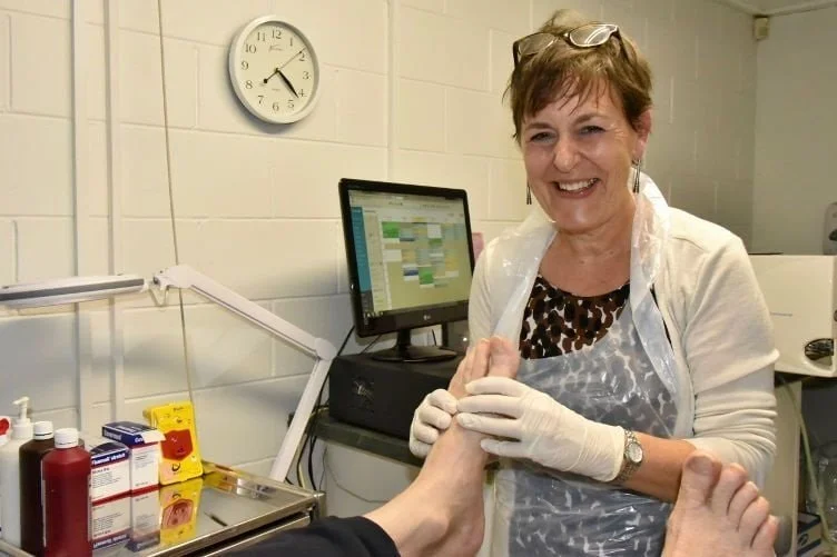 Podiatrist examining patient's foot for corns, calluses and sports injuries in Auckland podiatry clinic