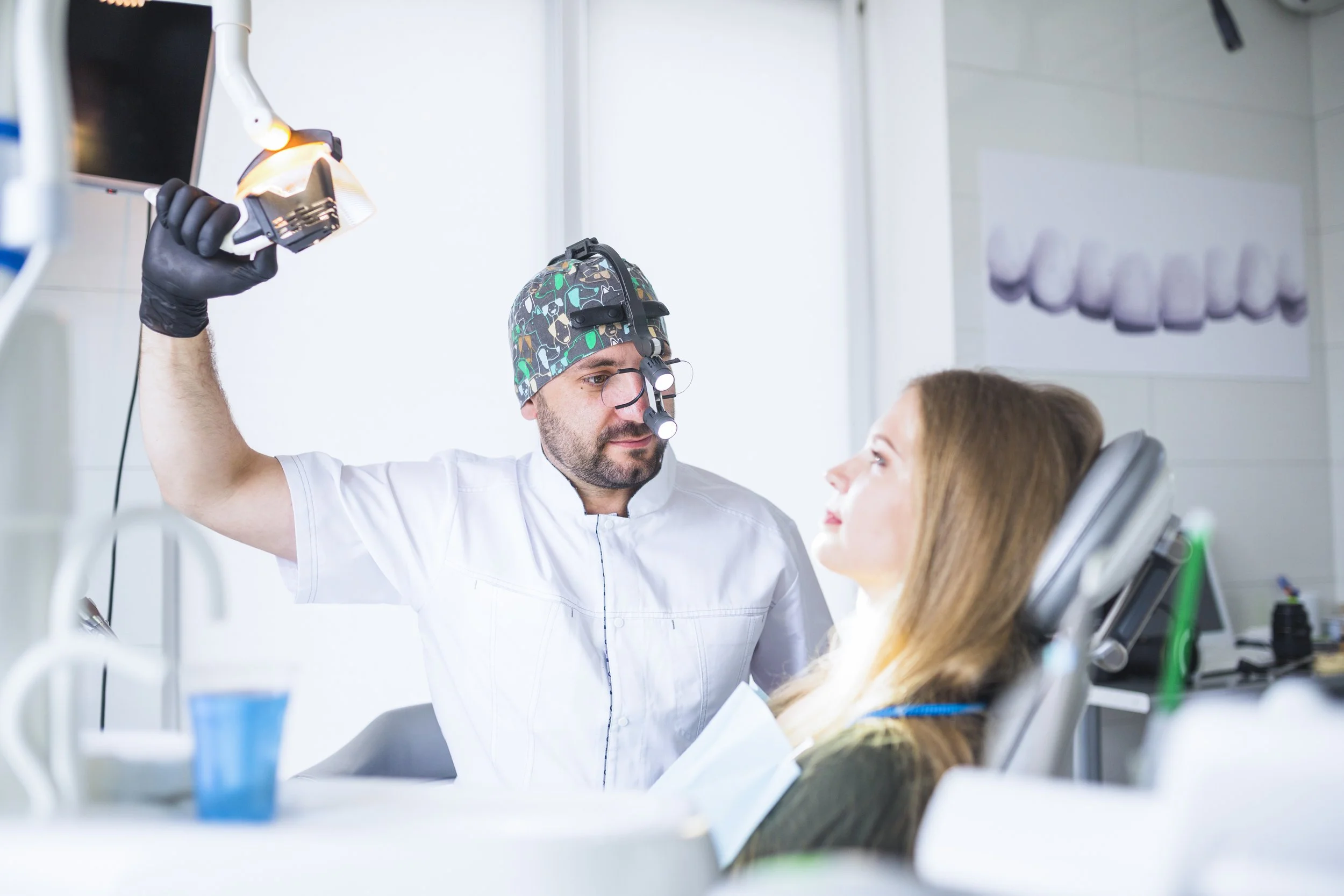 A dentist examining a patient in the dental chair