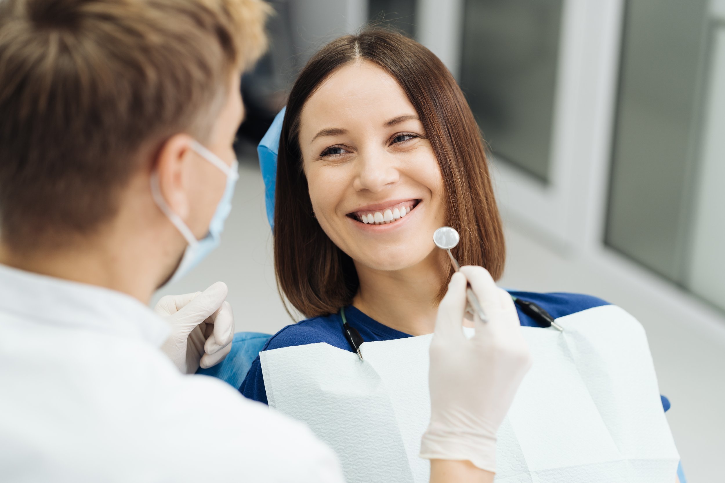 A smiling patient talking with her dentist