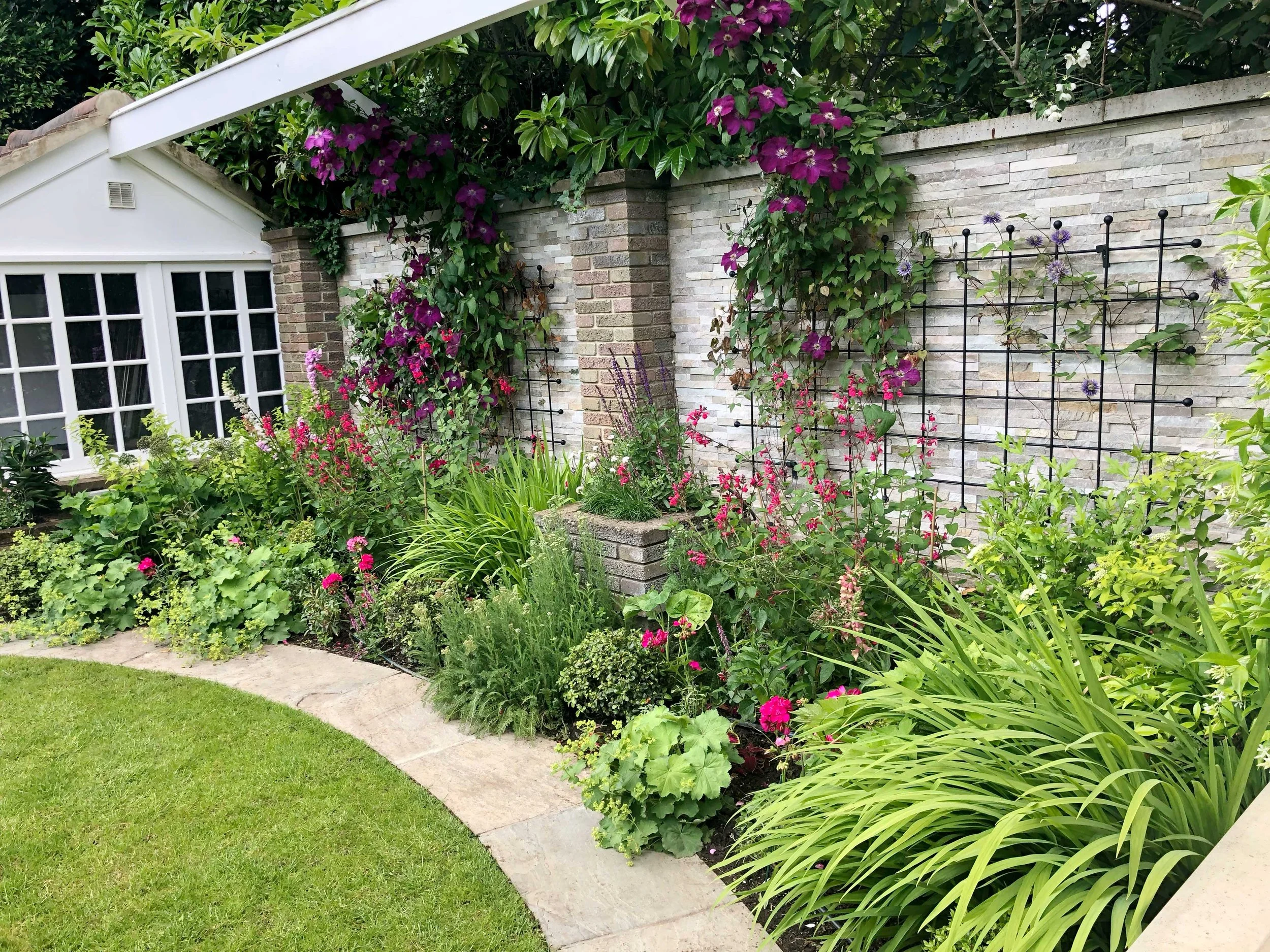 A succession of strong colours across the planting defines the personality of the garden