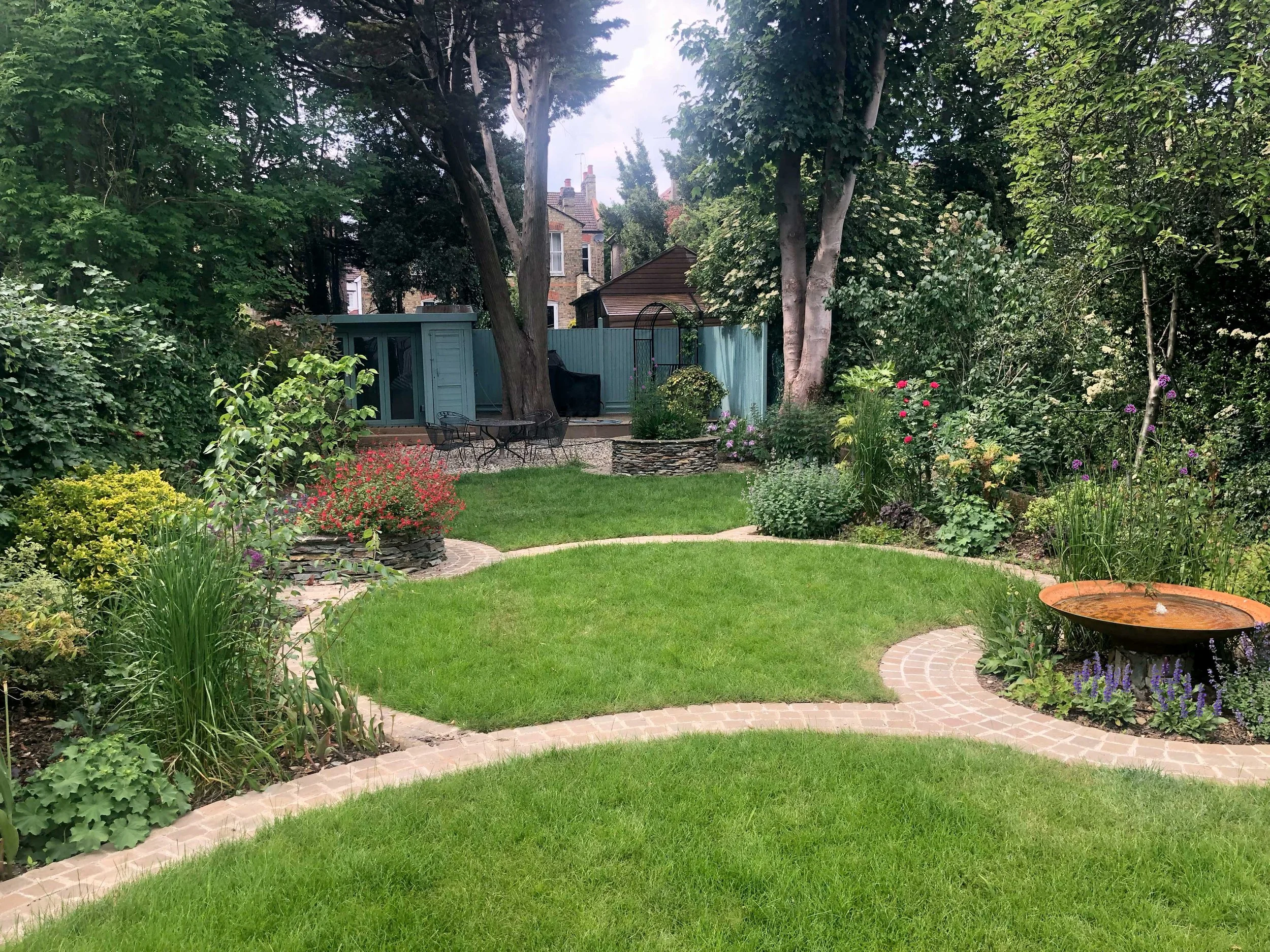 Circular inset stone pathway leads through garden past key features