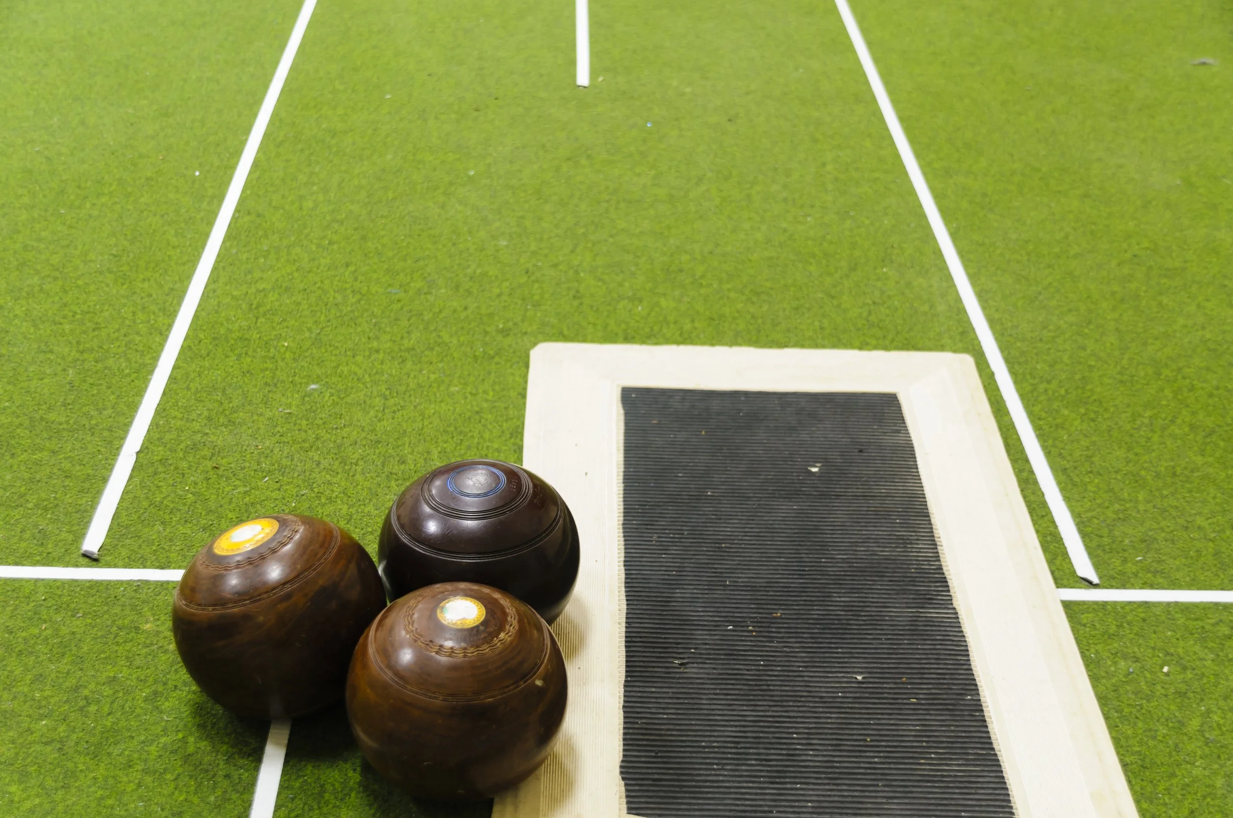 lawn bowls, with brown and yellow bowls laid out on the grass.