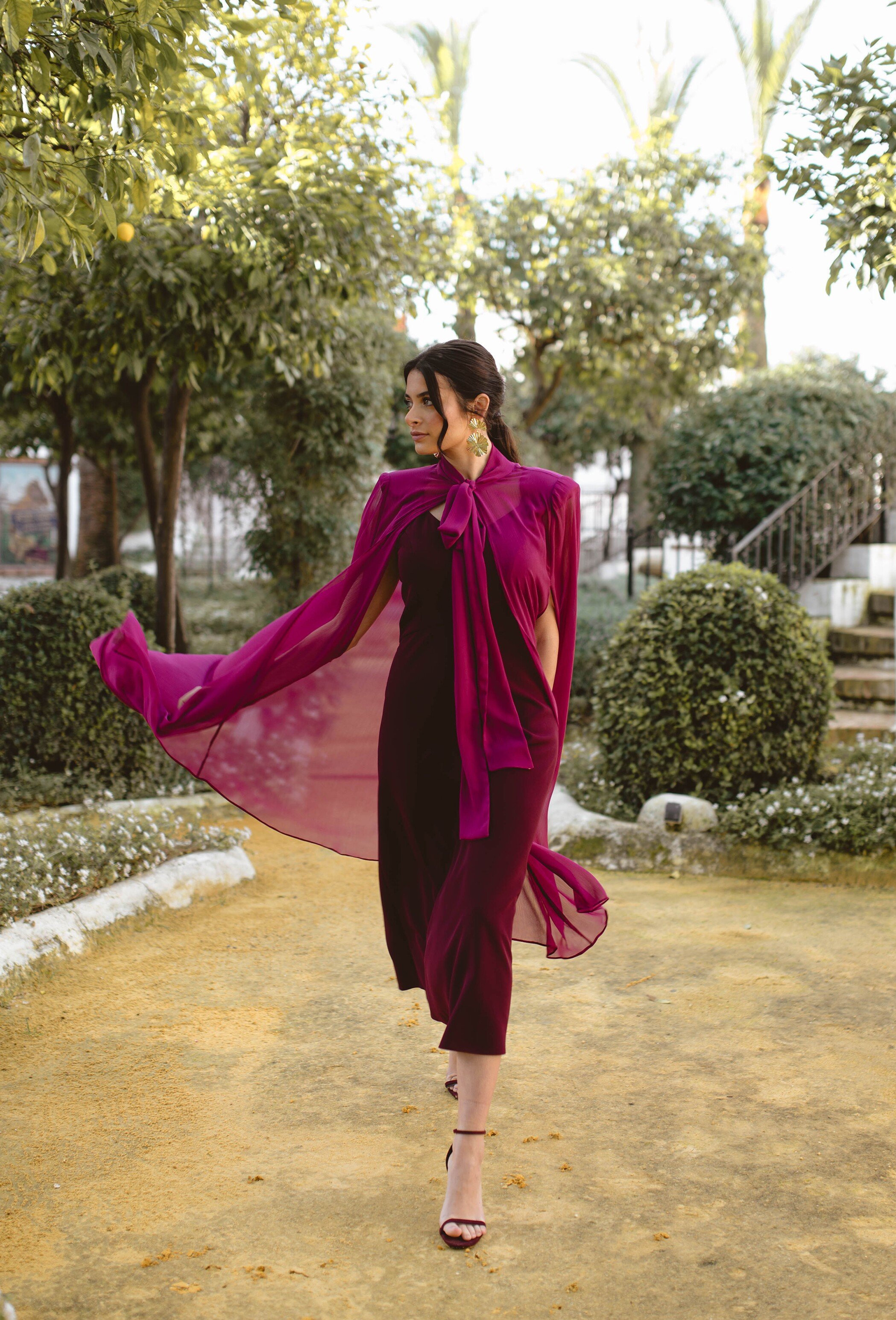 Model strolling through garden in guest dress at photo shoot