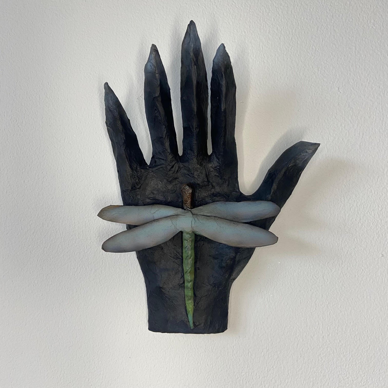 Transformation sculpture depicting a hand, crafted from repurposed materials