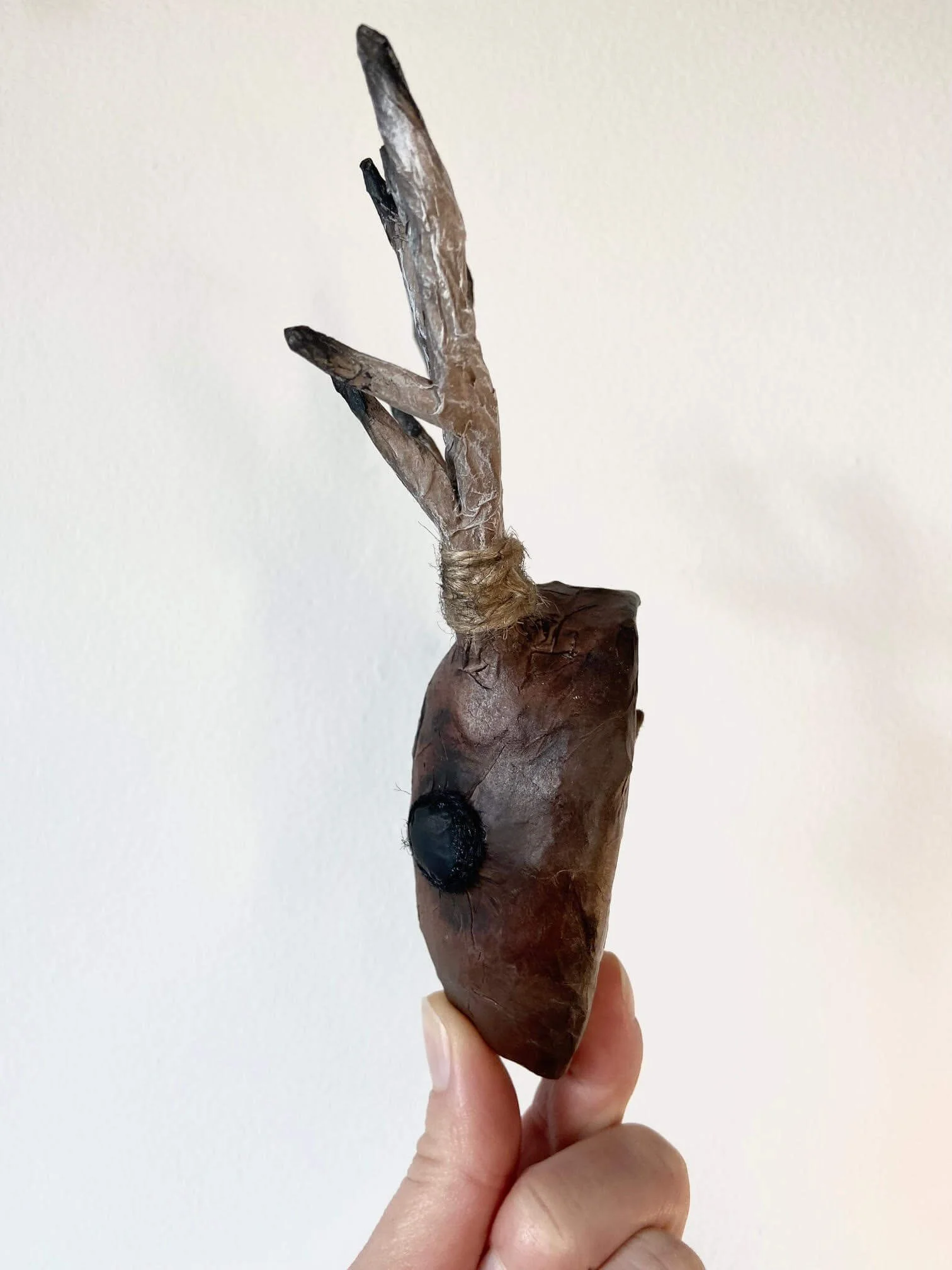 Trust miniature deer-head sculpture viewed in profile