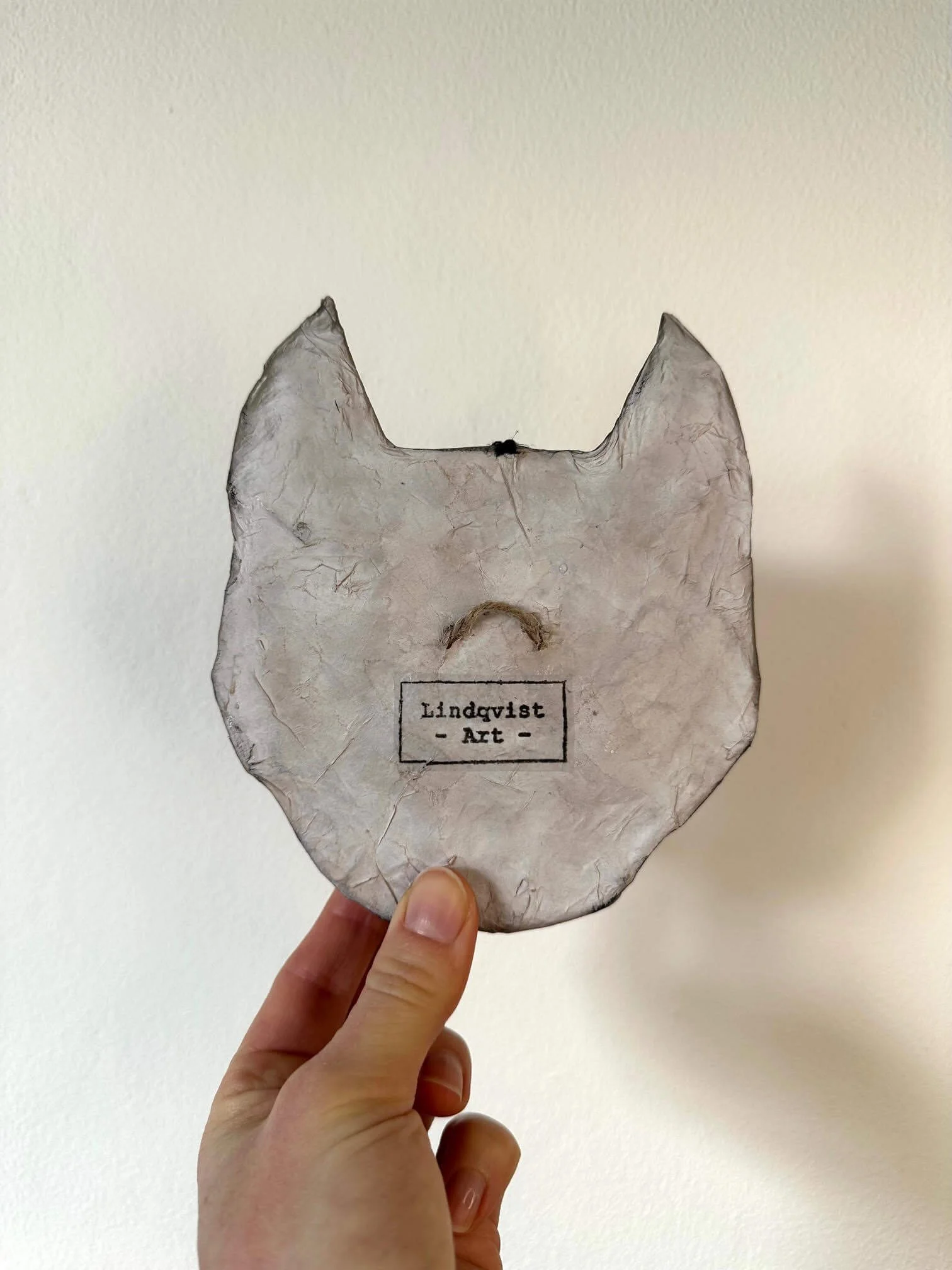 Instinct animal mask wall sculpture showing hanging loop and Lindqvist Art stamp on the backside.