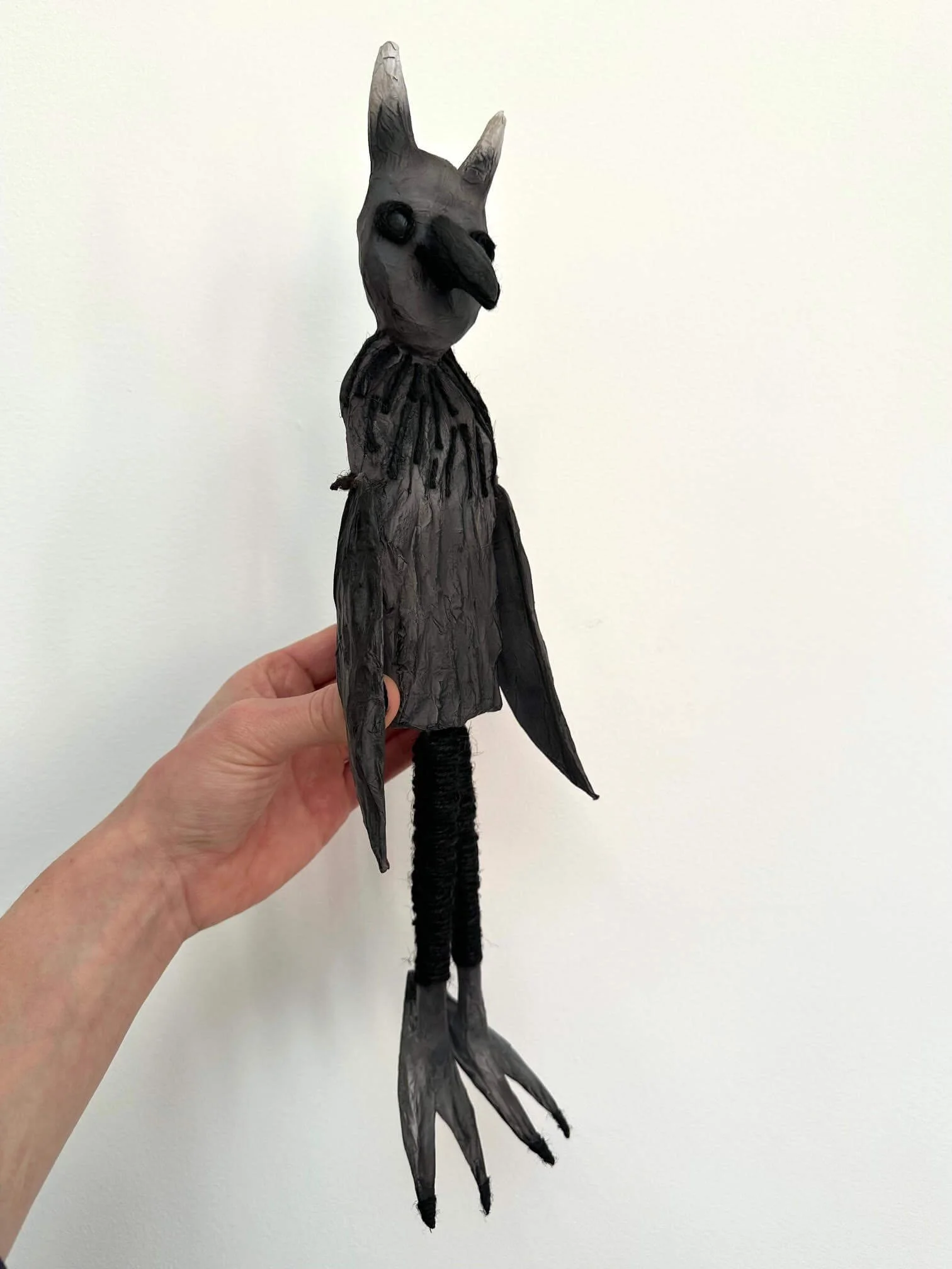 Crow Creature, a cardboard and paper sculpture in side view