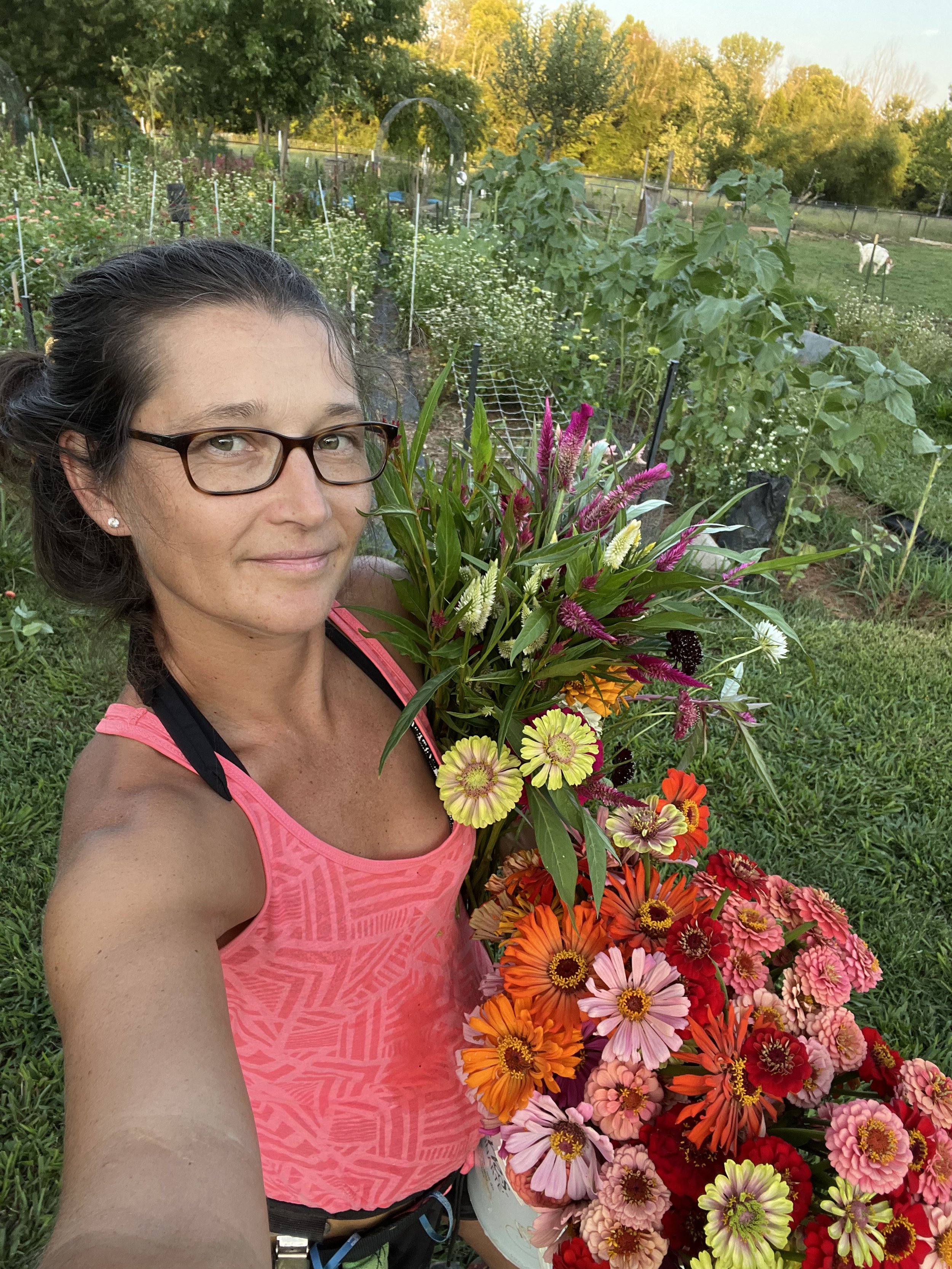 Woman holding a bouquet of colorful flowers in a garden setting