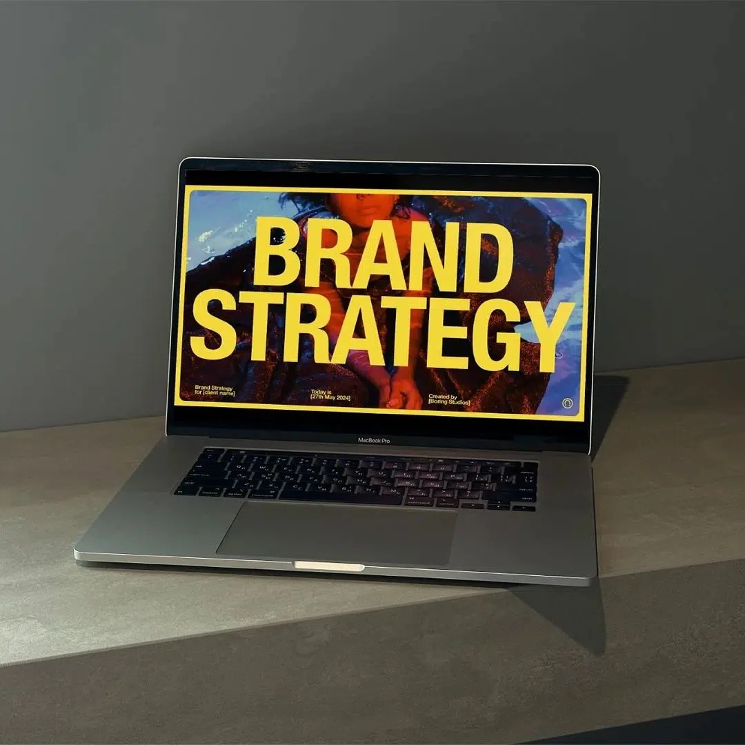 Laptop displaying a presentation titled "Brand Strategy" on the screen.