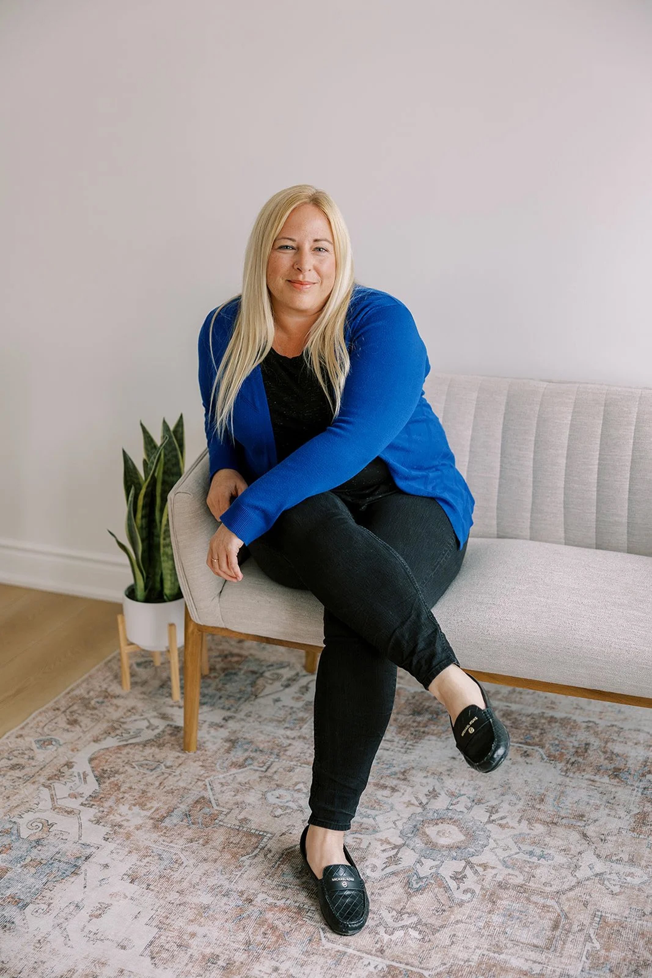 Shannon Brown, associate therapist, seated on a sofa in a counseling clinic, specializes in addiction support, coping skills, and mental health care