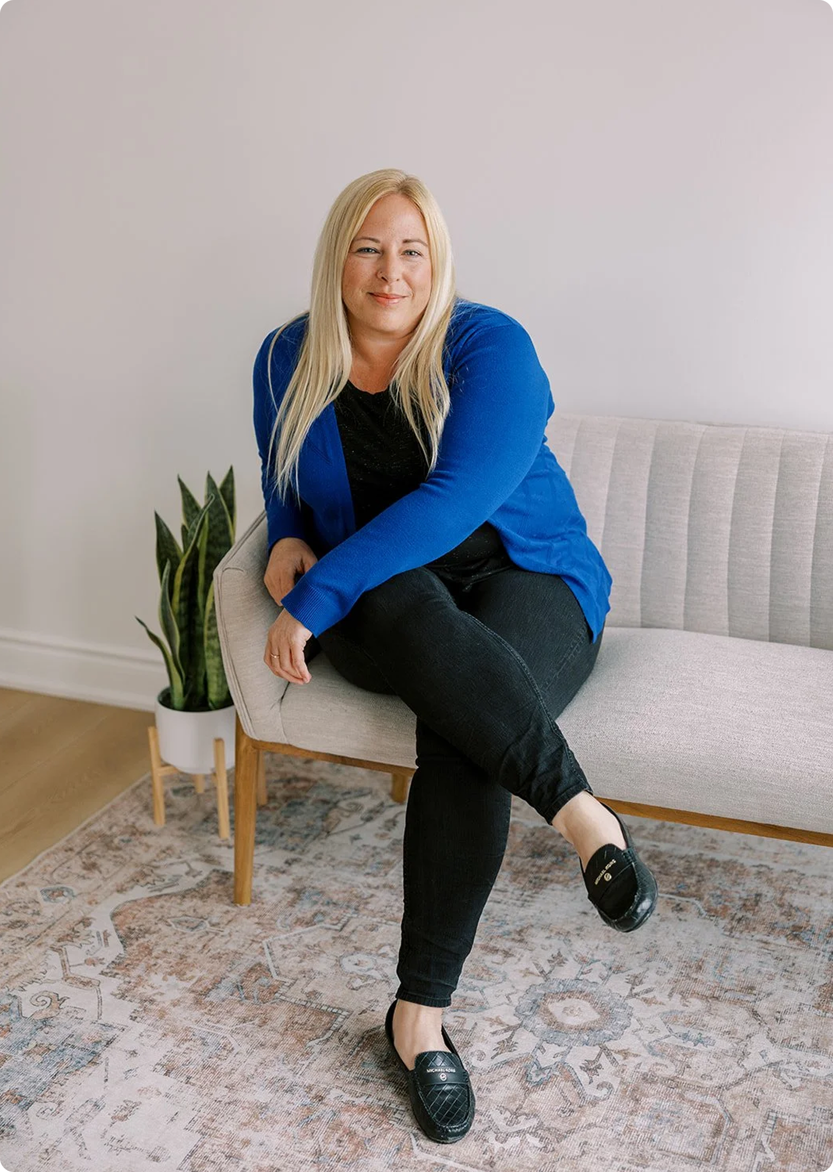 Mental health therapist sitting comfortably in a cozy, neutral-toned environment, conveying approachable psychotherapy, emotional support, and personalized counseling care.