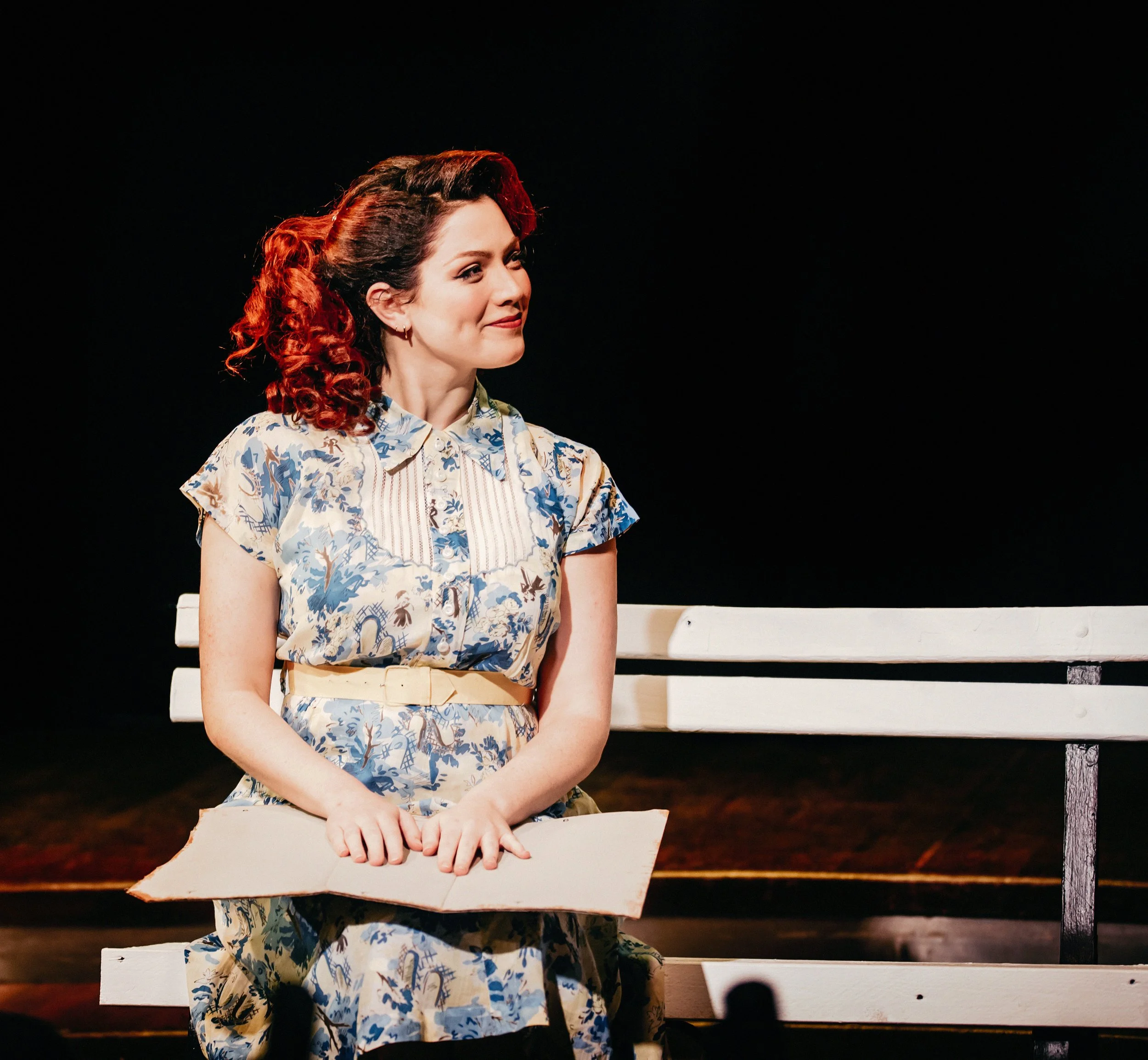 Riley Luettgen as Mary Lane sitting on a bench in Outskirt Theatre's production of Reefer Madness