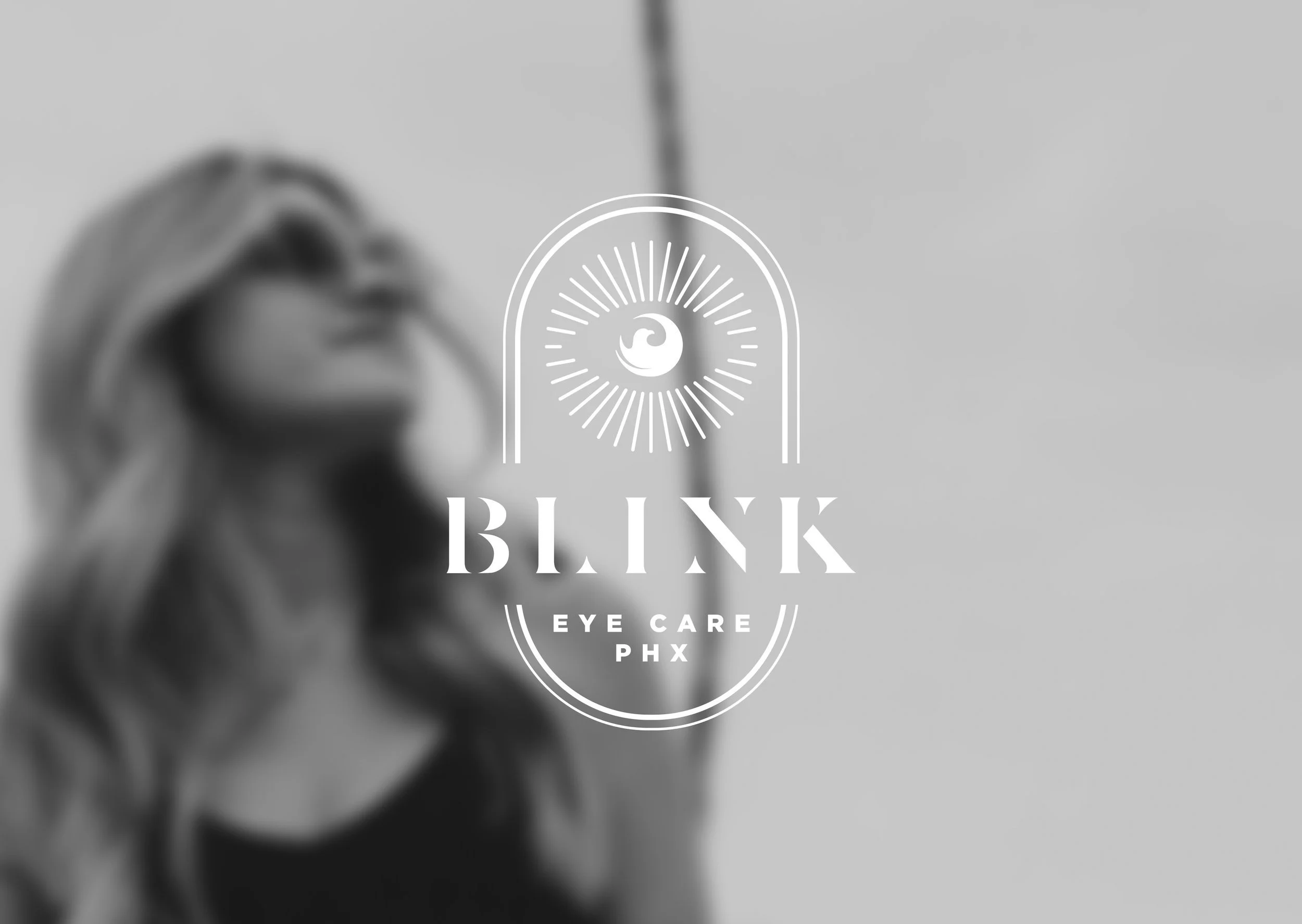 Black and white logo for 'Black Eye Care PHX' over a blurred image of a woman with long hair wearing a face mask and glasses.