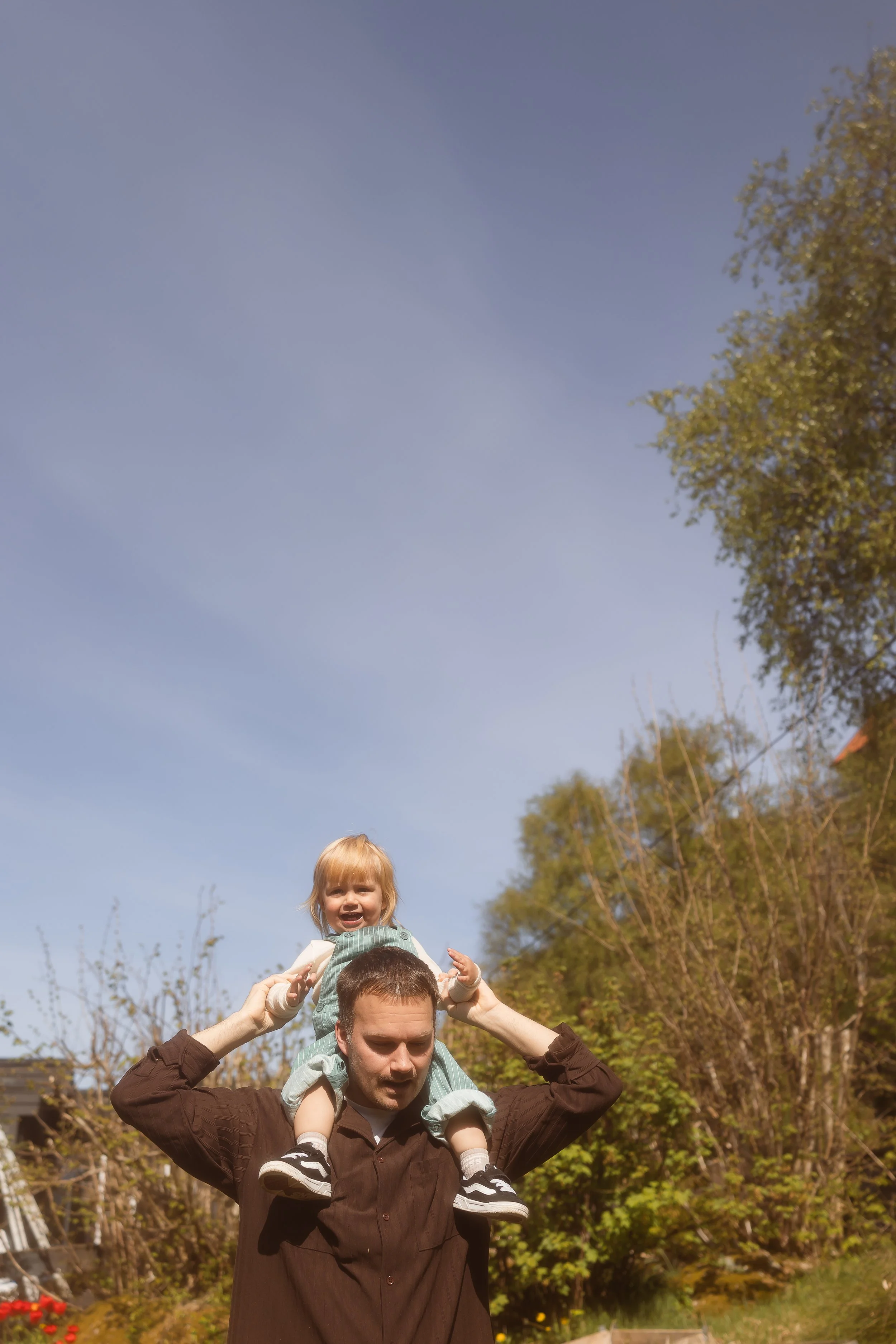 sønn som sitter på skuldra til pappaen 
